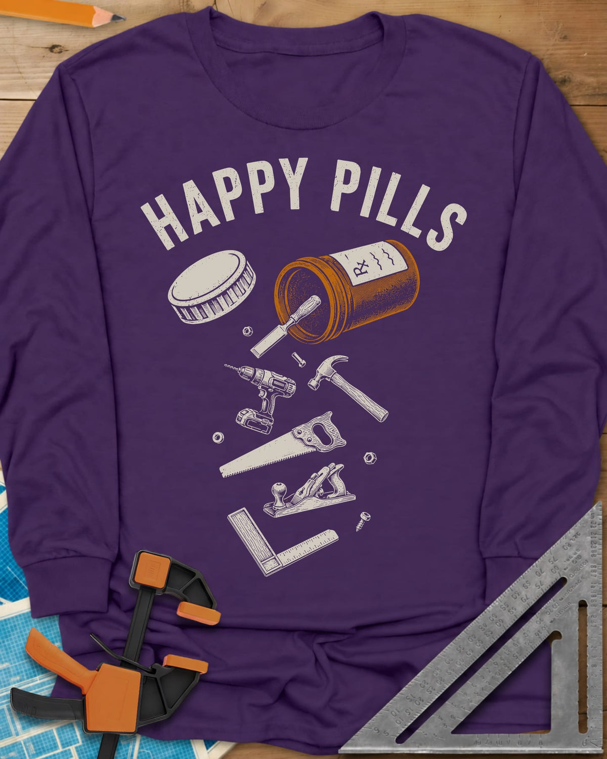 Happy Pills long sleeve shirt in Purple, a tipped pill bottle spilling hand tools and a cordless drill