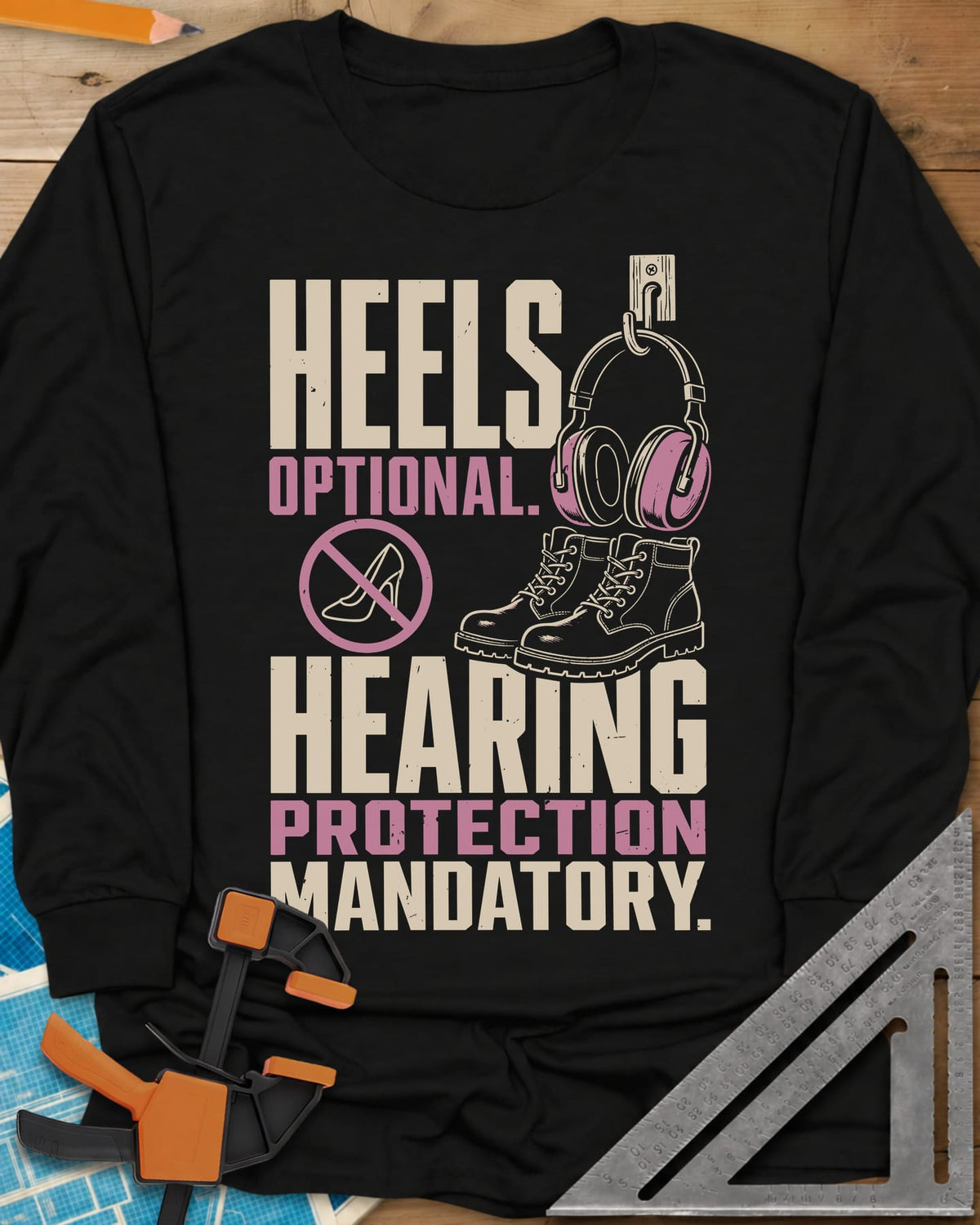 Hearing Protection long sleeve shirt in Black, ear muffs on a hook, work boots and a crossed-out high heel