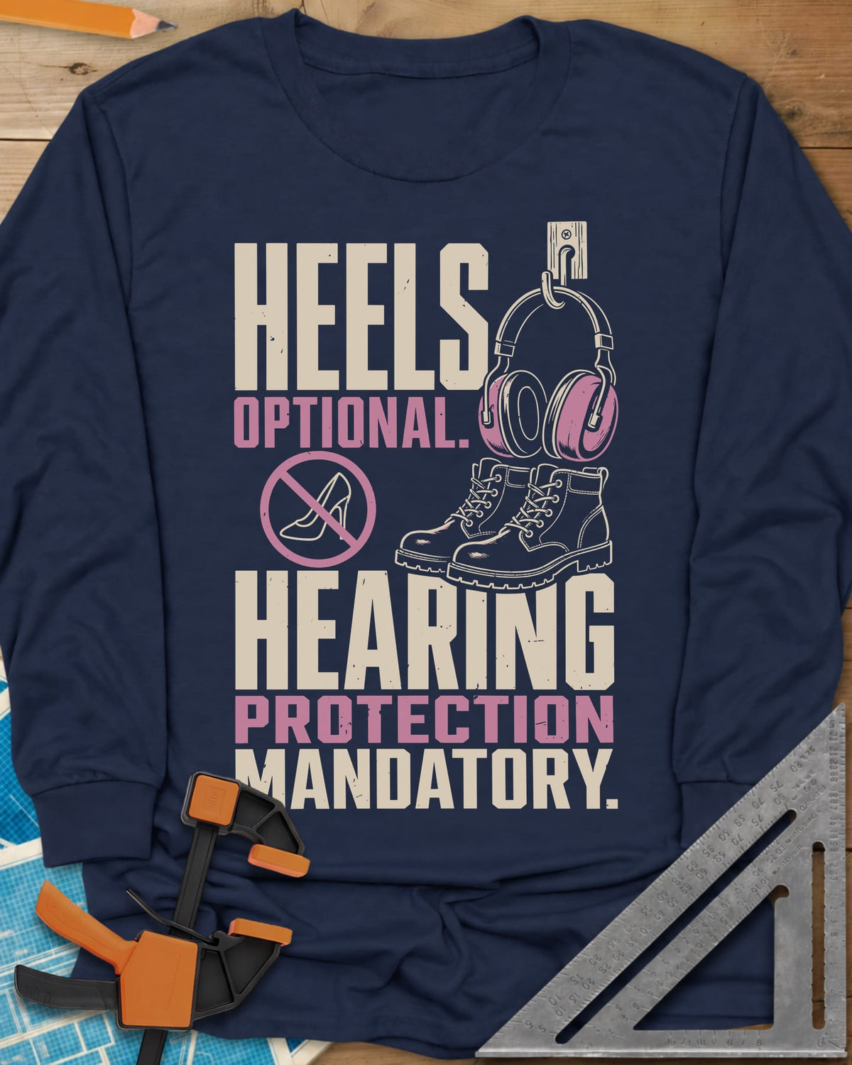 Hearing Protection long sleeve shirt in Navy, ear muffs on a hook, work boots and a crossed-out high heel