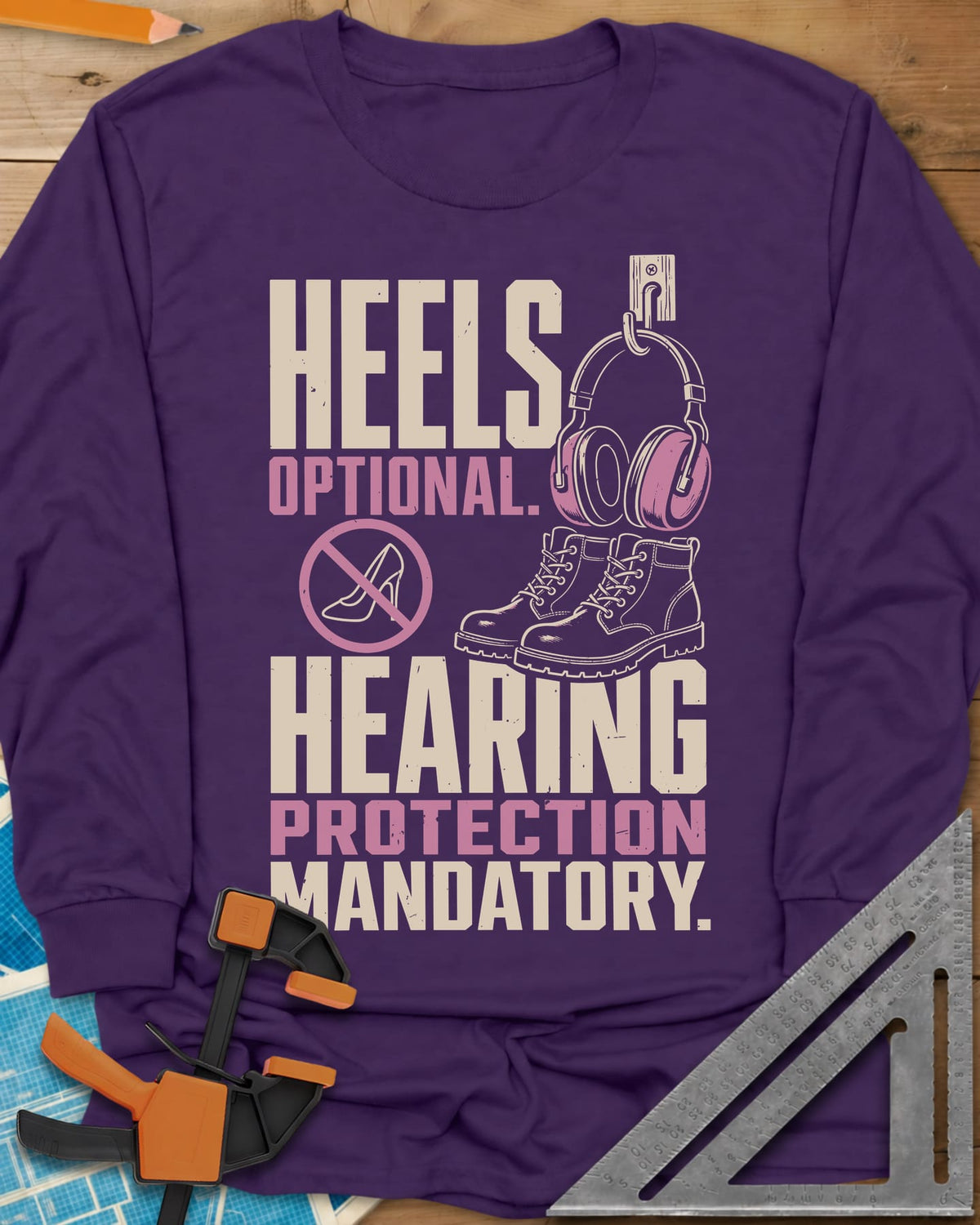 Hearing Protection long sleeve shirt in Purple, ear muffs on a hook, work boots and a crossed-out high heel