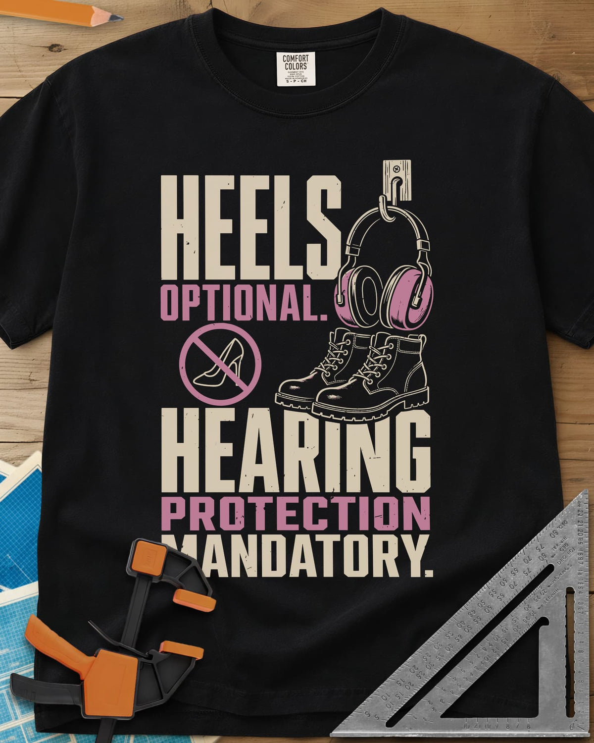 Hearing Protection heavyweight tee in Black, ear muffs on a hook, work boots and a crossed-out high heel