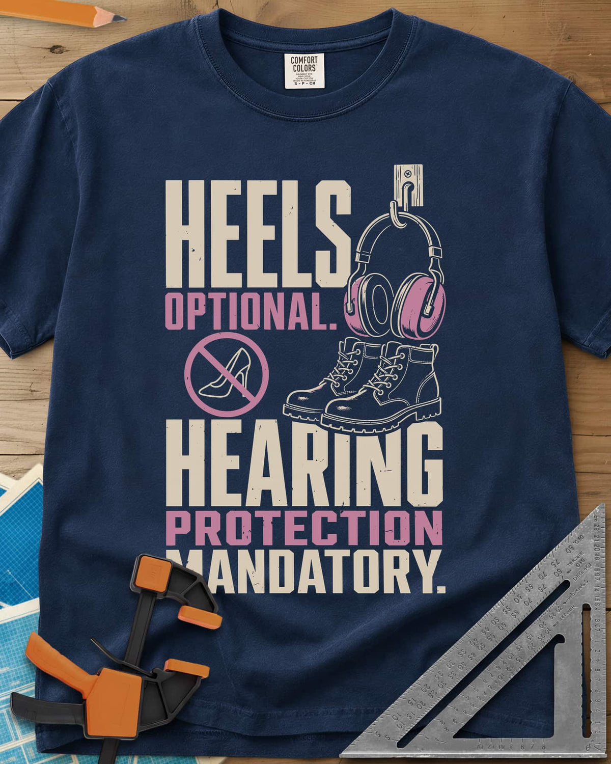 Hearing Protection heavyweight tee in Navy, ear muffs on a hook, work boots and a crossed-out high heel