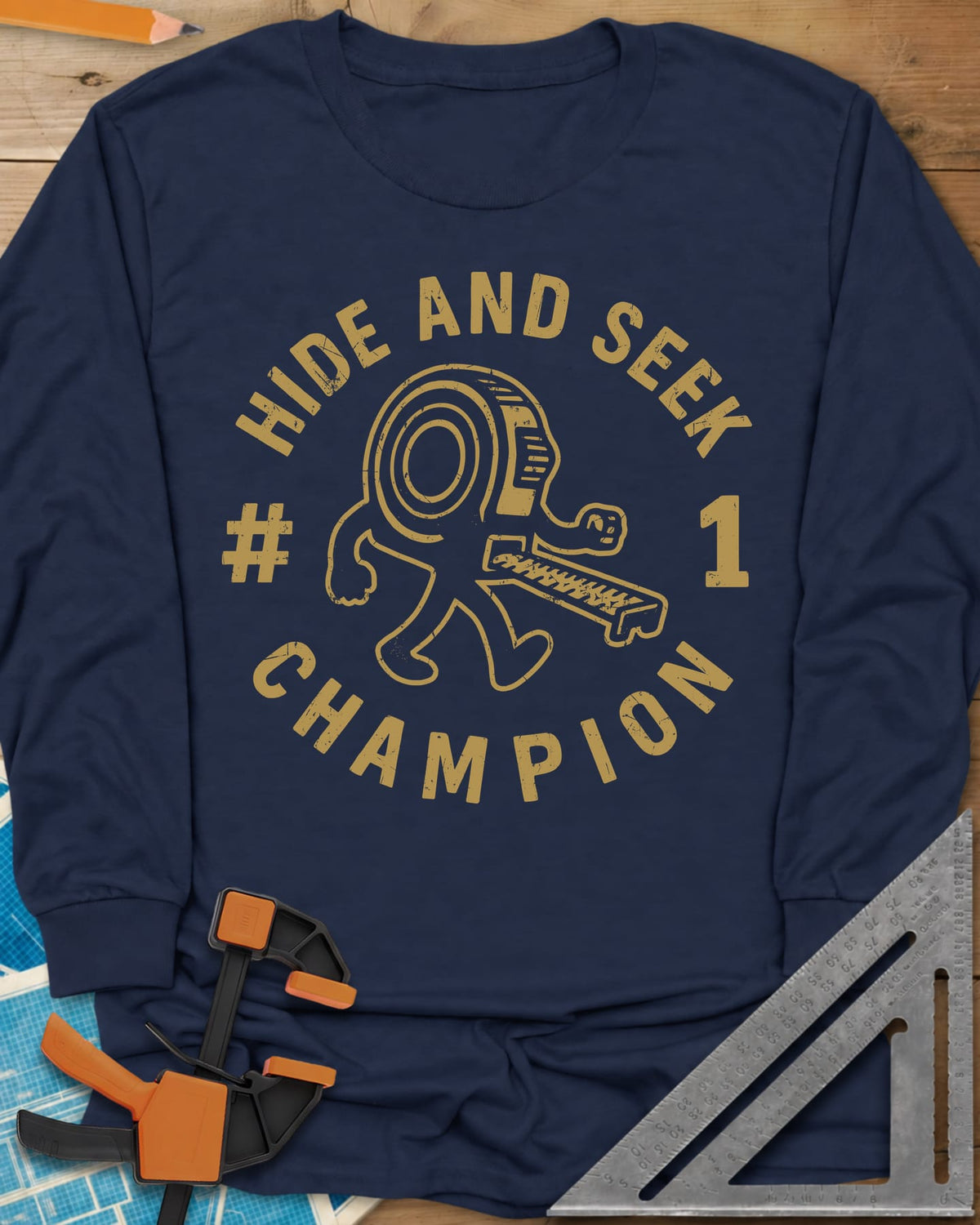 Hide And Seek long sleeve shirt in Navy, a walking tape measure character inside a round badge