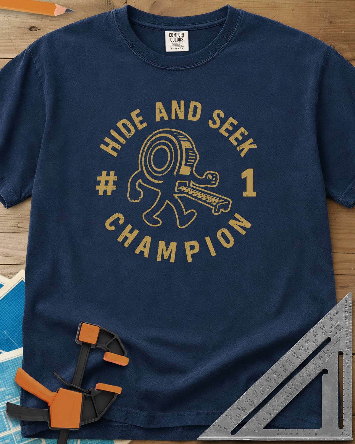 Hide And Seek heavyweight tee in Navy, a walking tape measure character inside a round badge