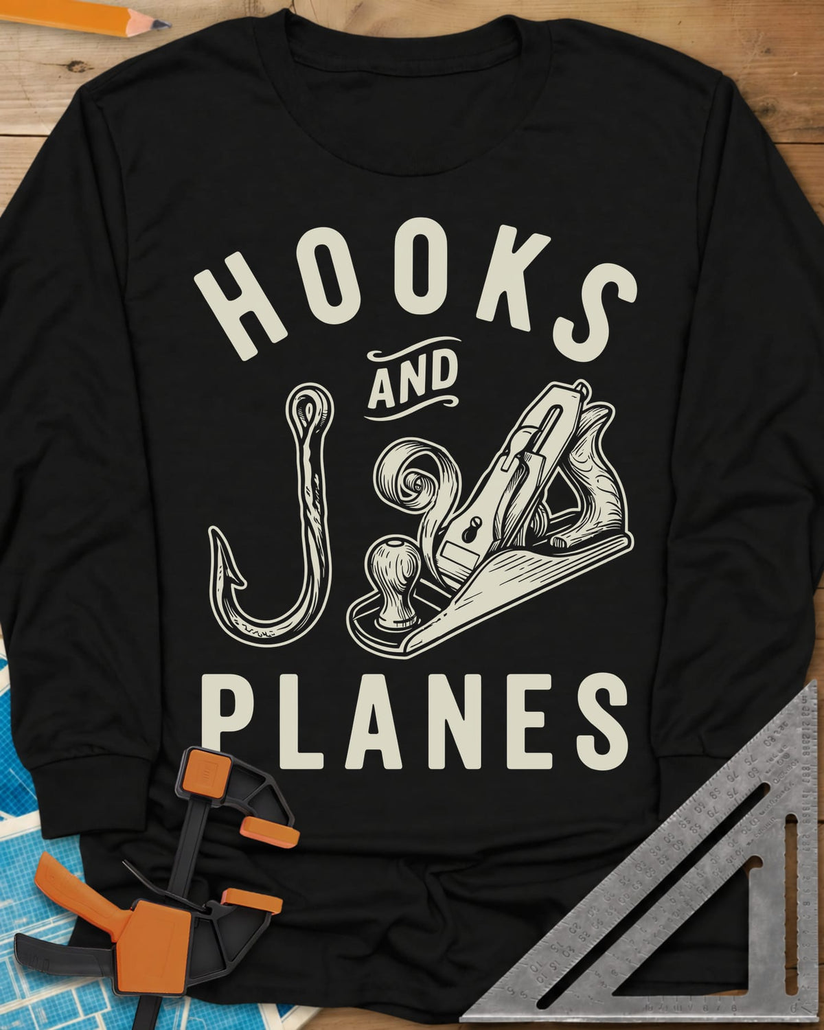 Hooks And Planes long sleeve shirt in Black, an engraved fish hook and a hand plane with a curl of shavings