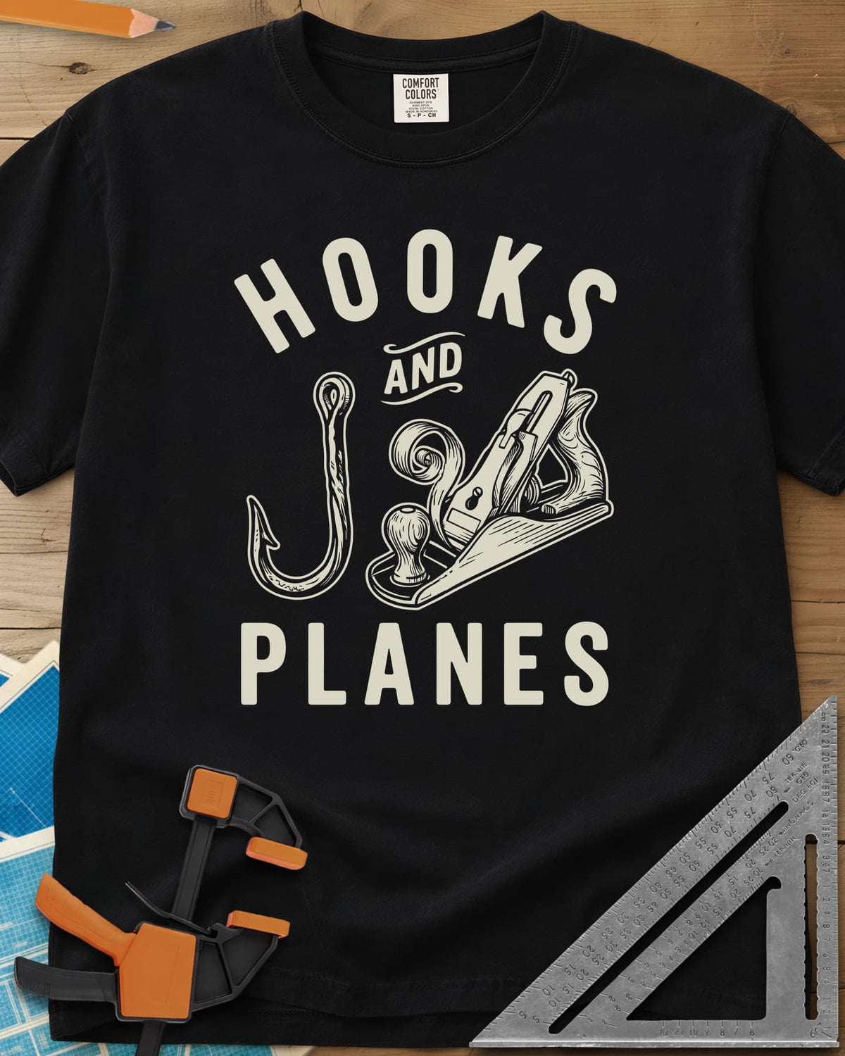 Hooks And Planes heavyweight tee in Black, an engraved fish hook and a hand plane with a curl of shavings