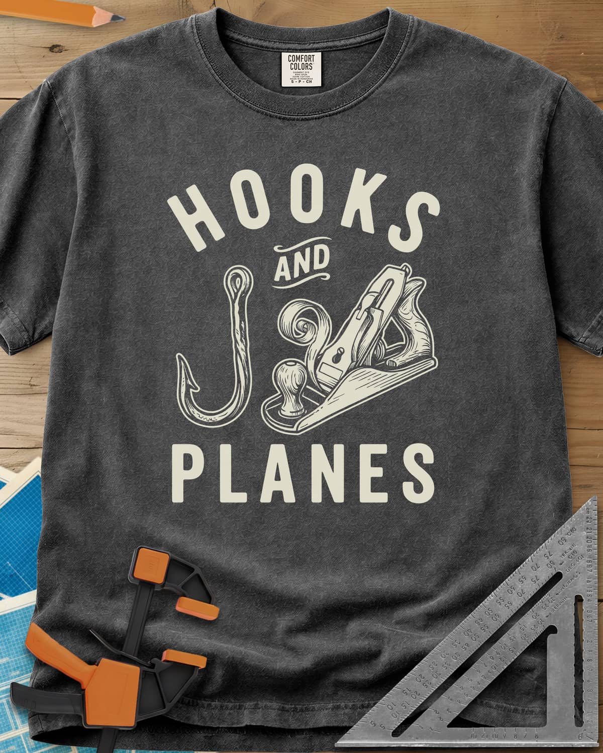 Hooks And Planes heavyweight tee in Pepper, an engraved fish hook and a hand plane with a curl of shavings