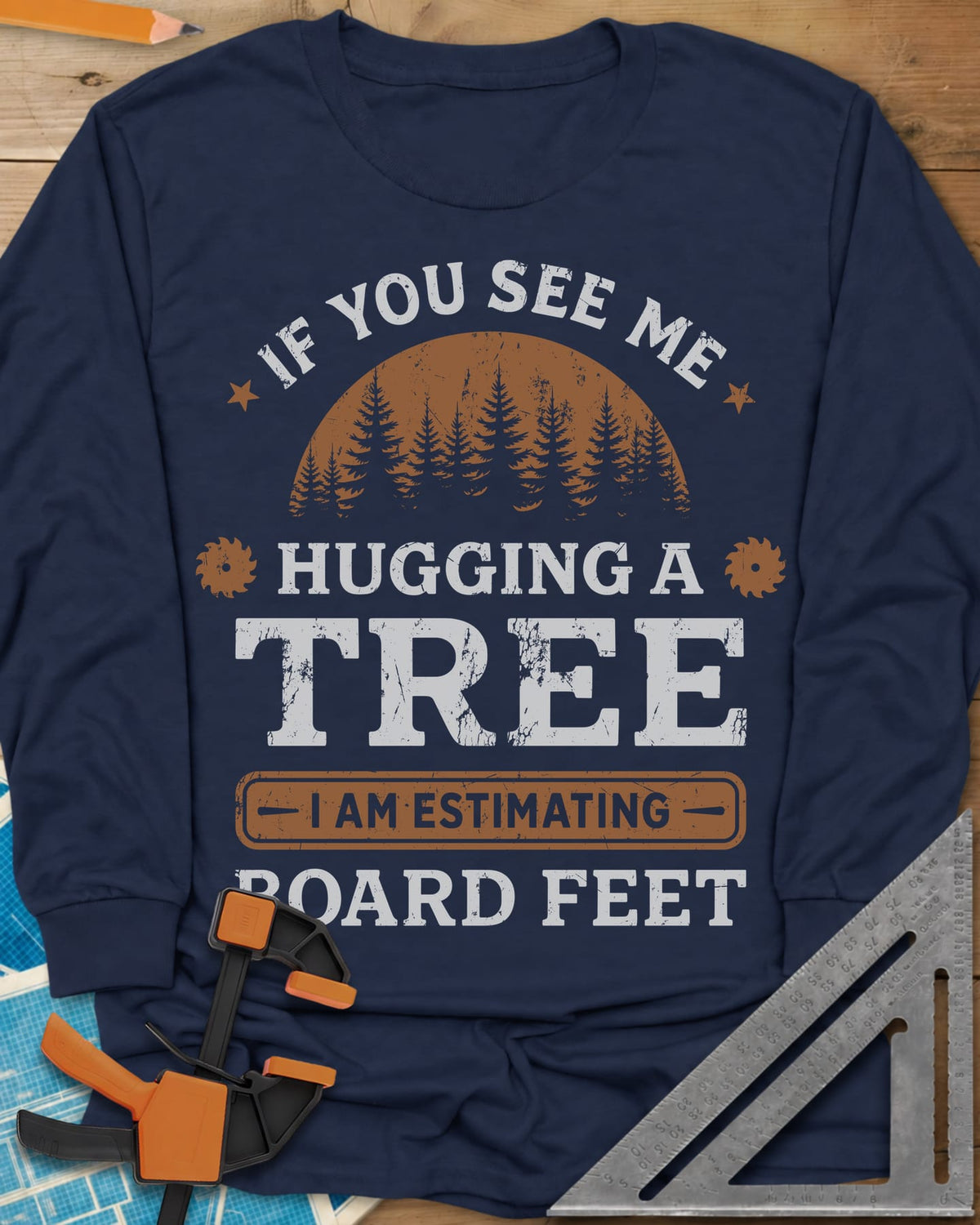 Hugging a Tree long sleeve shirt in Navy, a pine forest at sunset with two small saw blades