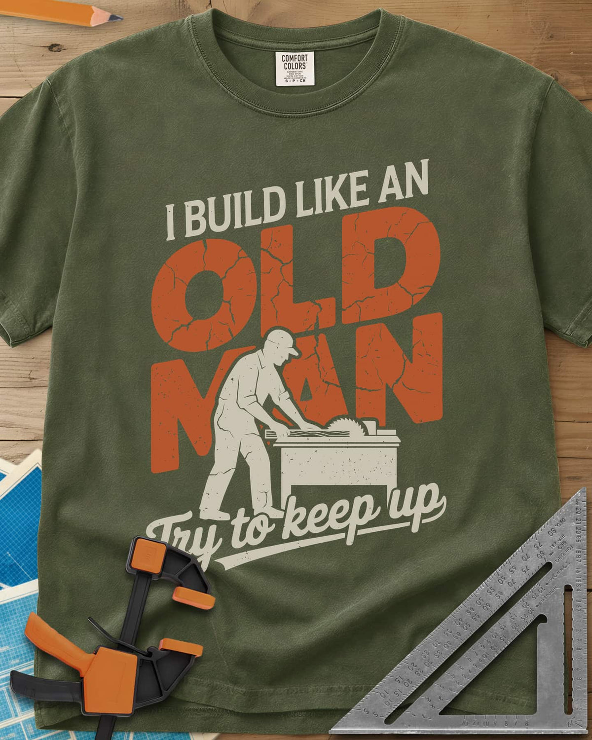 I Build Like An Old Man Woodworking heavyweight tee in Hemp, a man in a cap pushing a board through a table saw