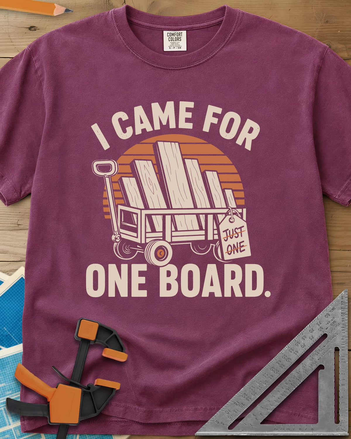 I Came For One Board heavyweight tee in Berry, a wagon stacked with boards and a struck-out JUST ONE tag