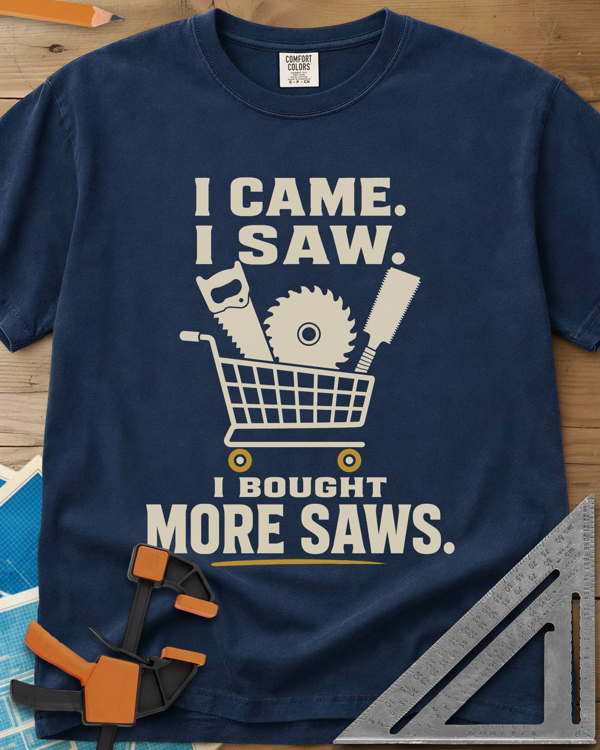I Came I Saw I Bought More Saws heavyweight tee in Navy, a shopping cart holding a handsaw, a saw blade and a pull saw