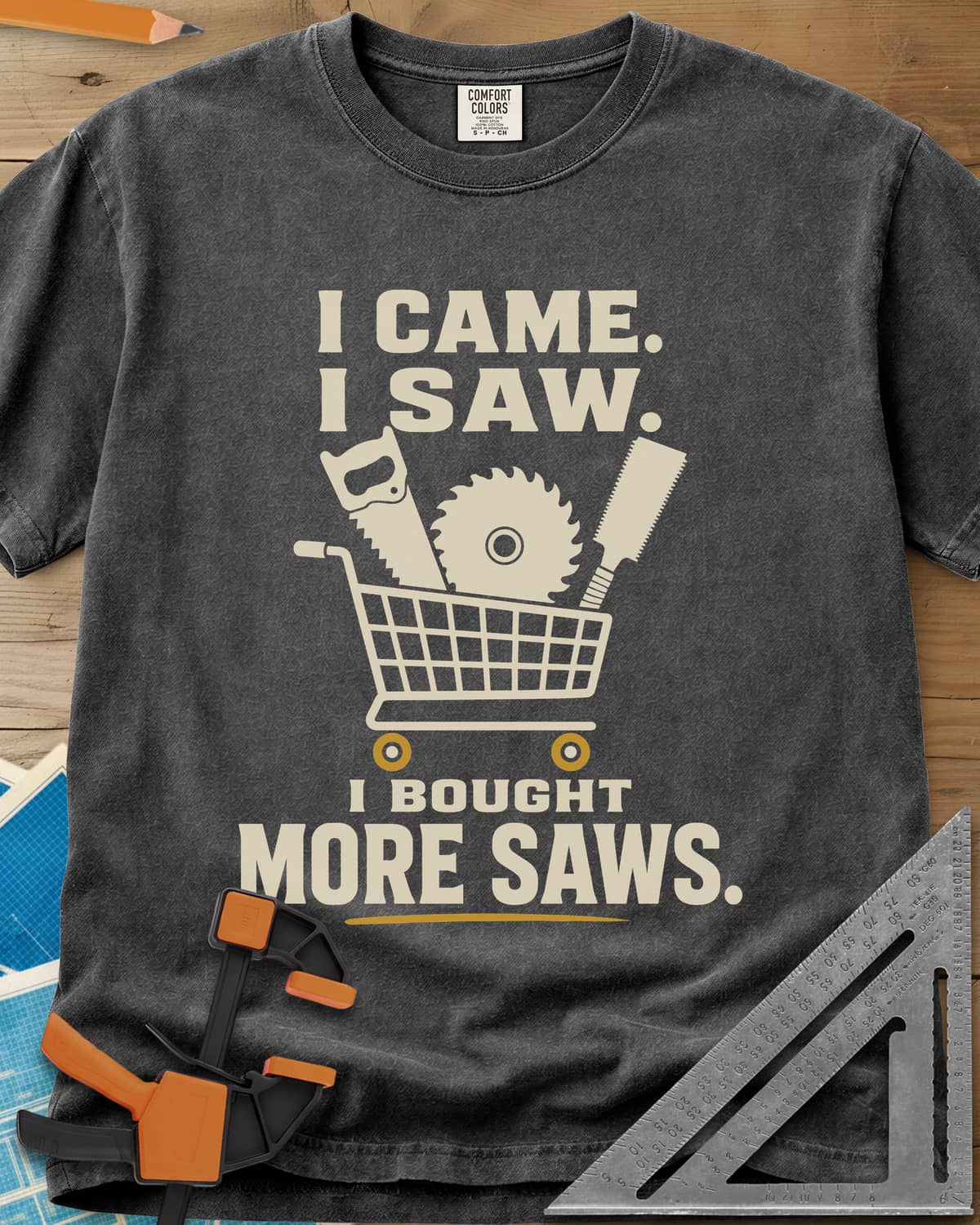I Came I Saw I Bought More Saws heavyweight tee in Pepper, a shopping cart holding a handsaw, a saw blade and a pull saw