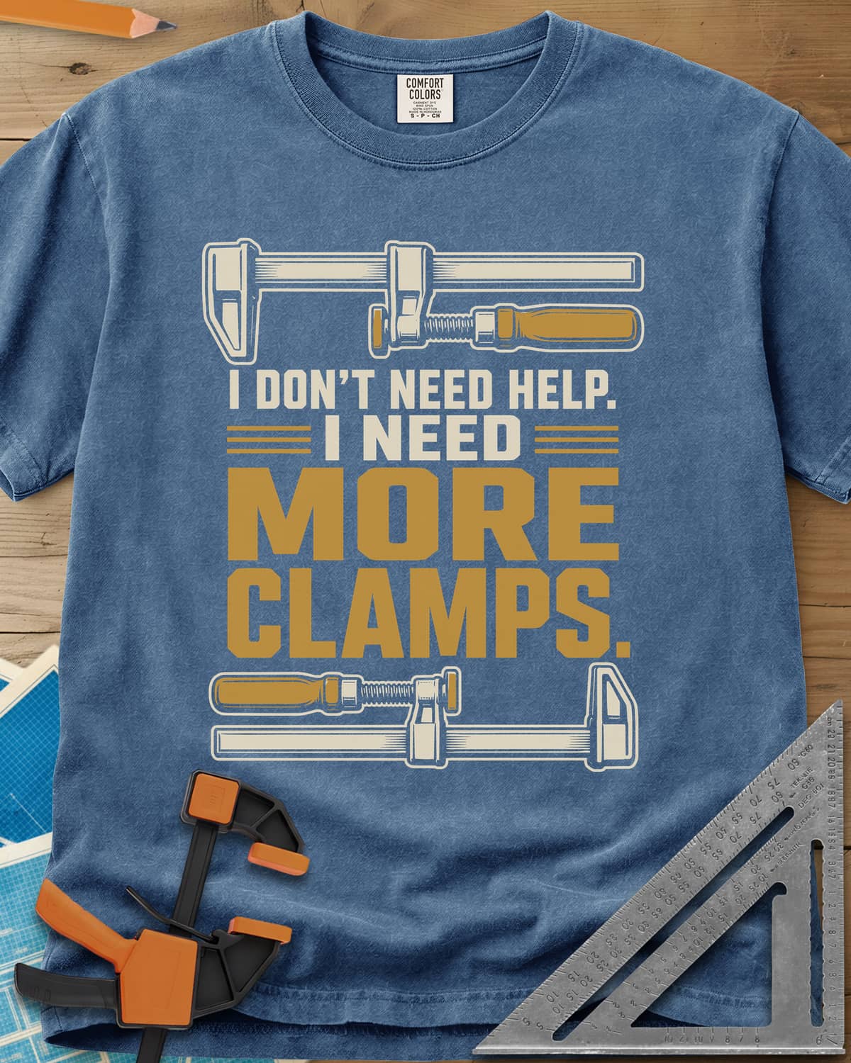 I Don't Need Help I Need More Clamps heavyweight tee in Blue Jean, two bar clamps above and below bold stacked lettering