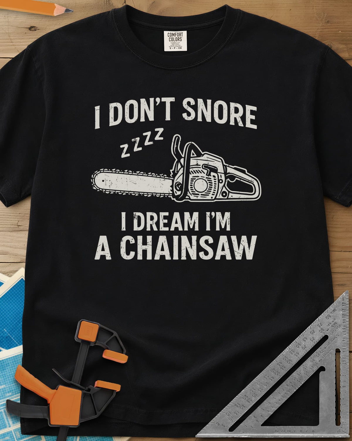 I Dream I'm A Chainsaw heavyweight tee in Black, a chainsaw with zzzz above it between two lines of text