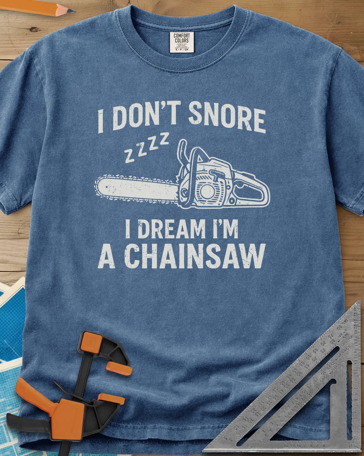 I Dream I'm A Chainsaw heavyweight tee in Blue Jean, a chainsaw with zzzz above it between two lines of text