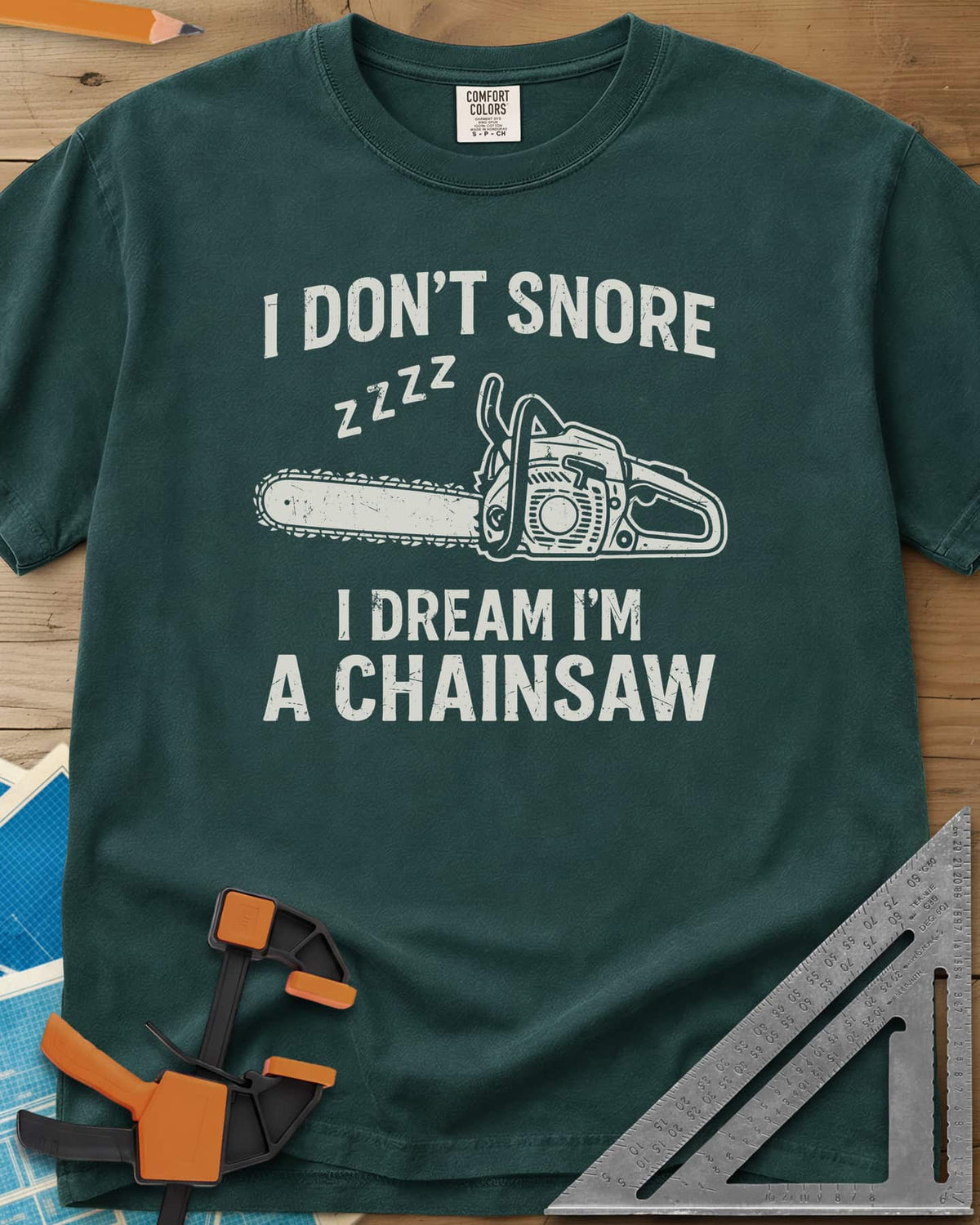 I Dream I'm A Chainsaw heavyweight tee in Blue Spruce, a chainsaw with zzzz above it between two lines of text