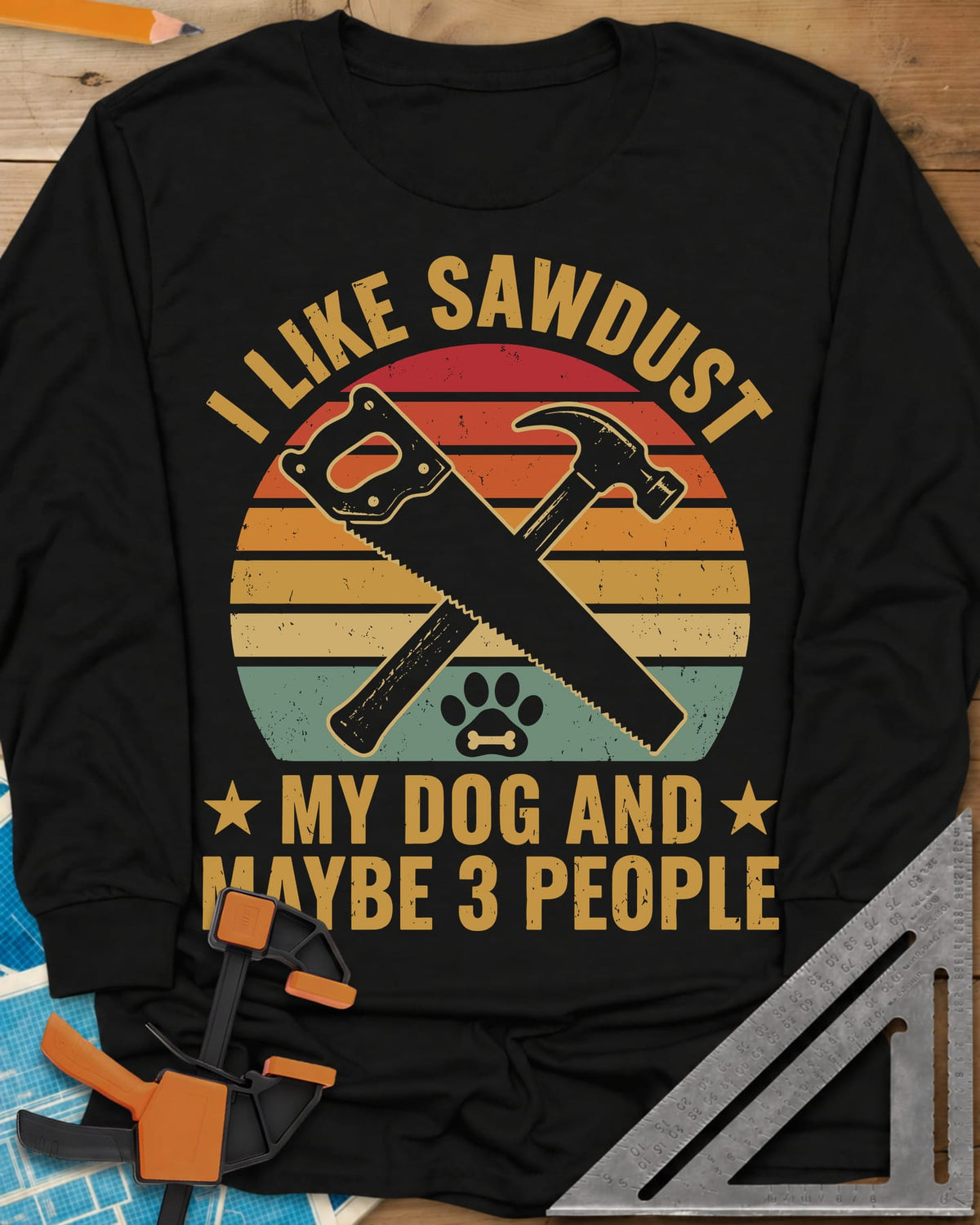 I Like Sawdust long sleeve shirt in Black, a hand saw crossed with a hammer over a paw print on retro stripes