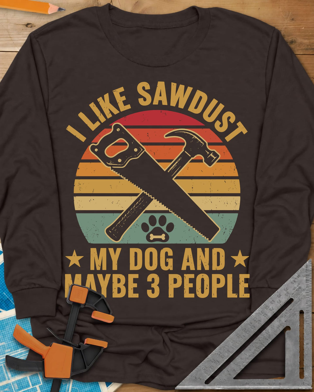 I Like Sawdust long sleeve shirt in Dark Chocolate, a hand saw crossed with a hammer over a paw print on retro stripes