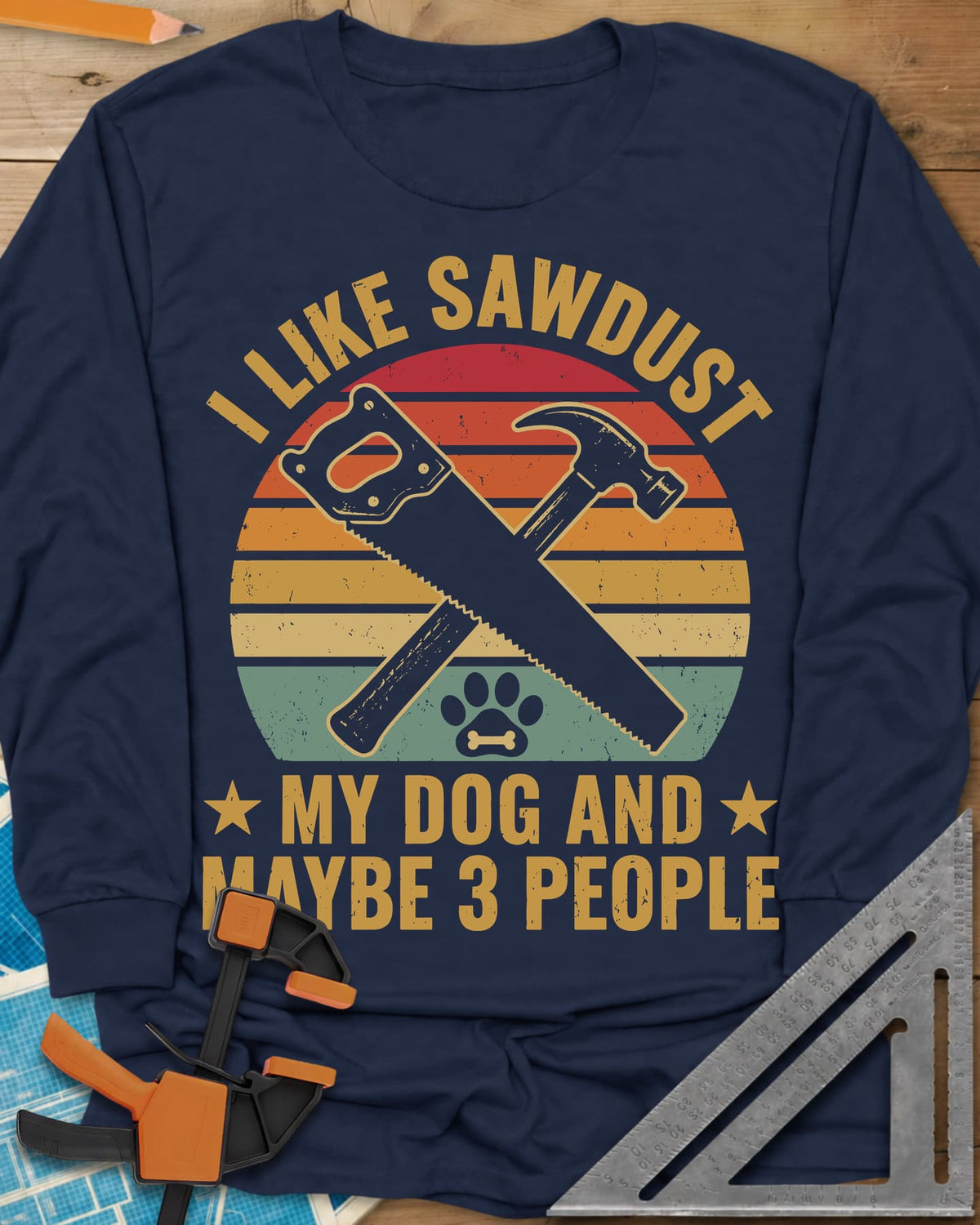 I Like Sawdust long sleeve shirt in Navy, a hand saw crossed with a hammer over a paw print on retro stripes