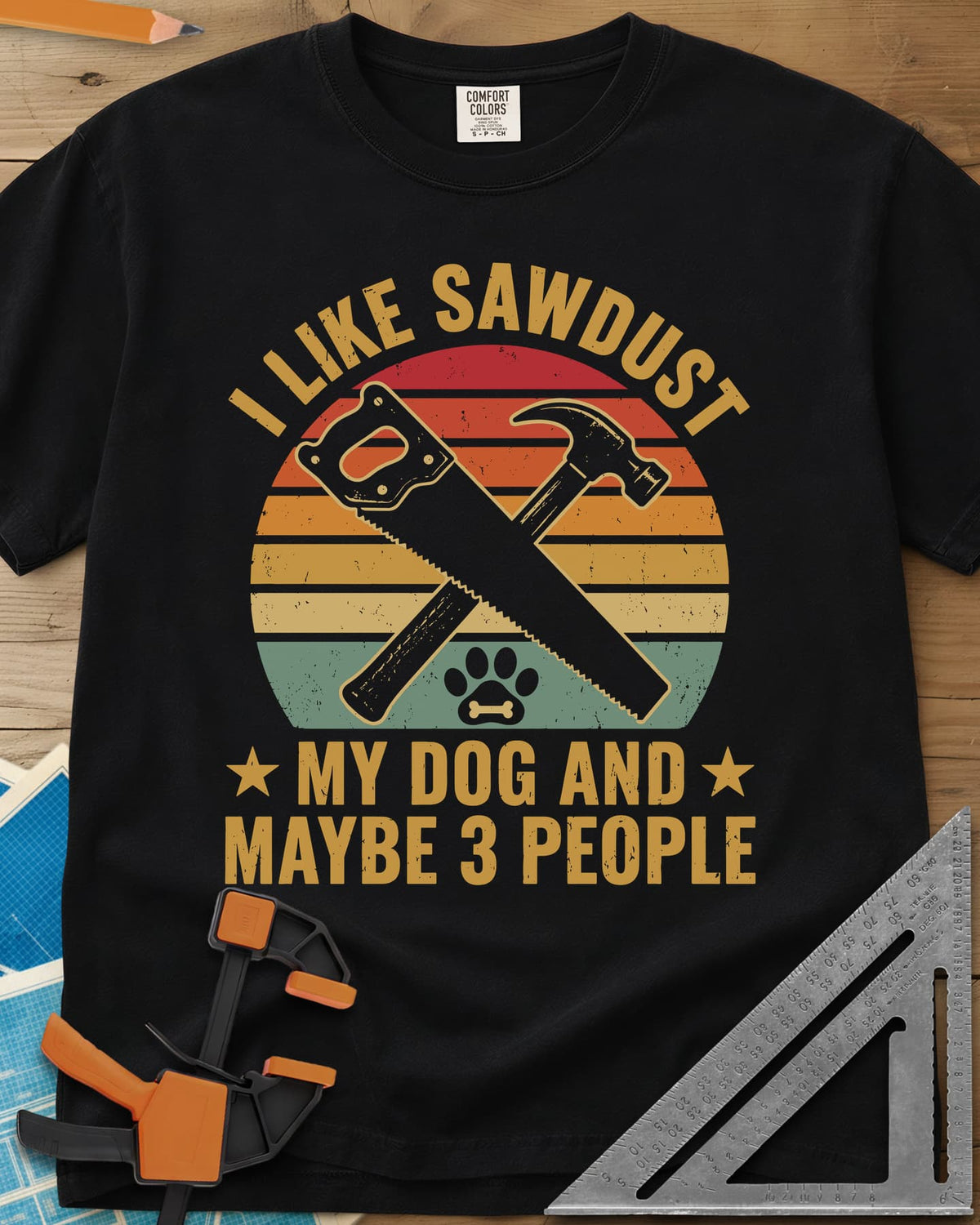 I Like Sawdust heavyweight tee in Black, a hand saw crossed with a hammer over a paw print on retro stripes