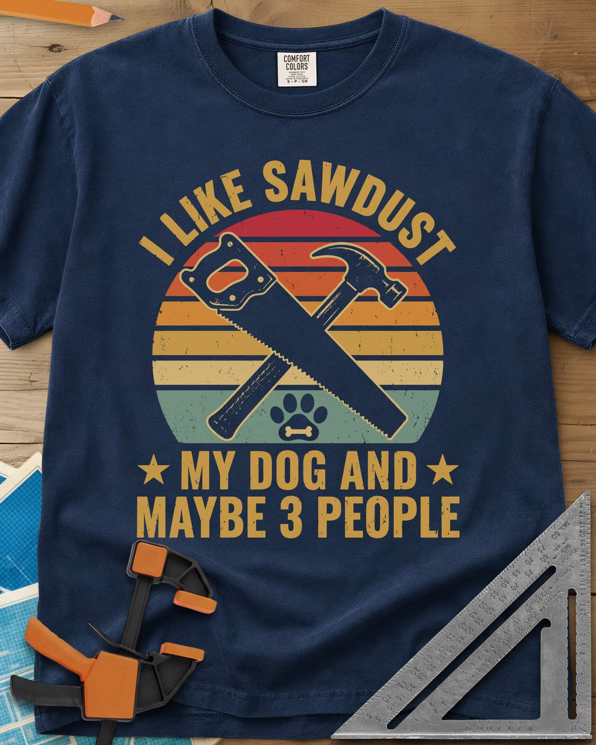 I Like Sawdust heavyweight tee in Navy, a hand saw crossed with a hammer over a paw print on retro stripes