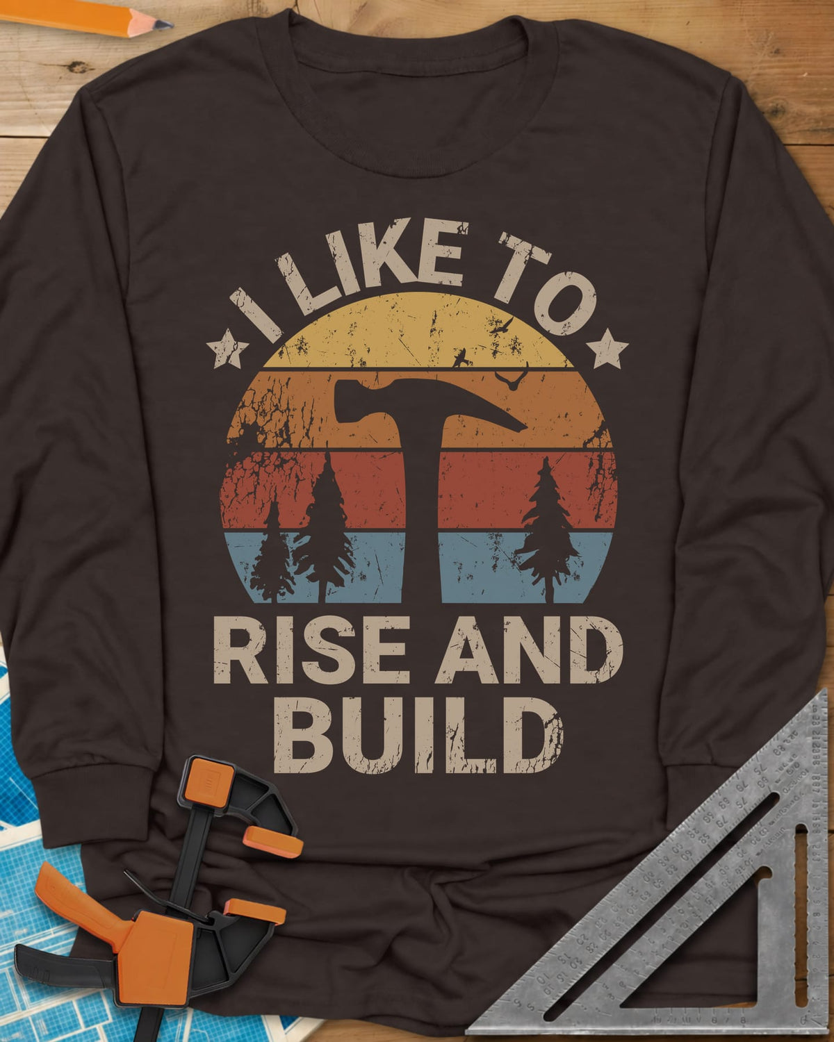 I Like To Rise And Build long sleeve shirt in Dark Chocolate, a retro striped sunset with a hammer silhouette and pine trees