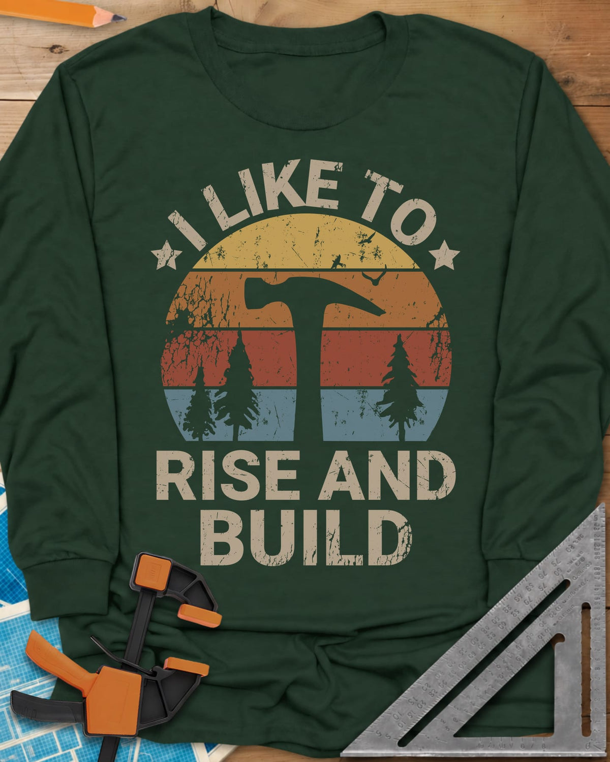 I Like To Rise And Build long sleeve shirt in Forest Green, a retro striped sunset with a hammer silhouette and pine trees