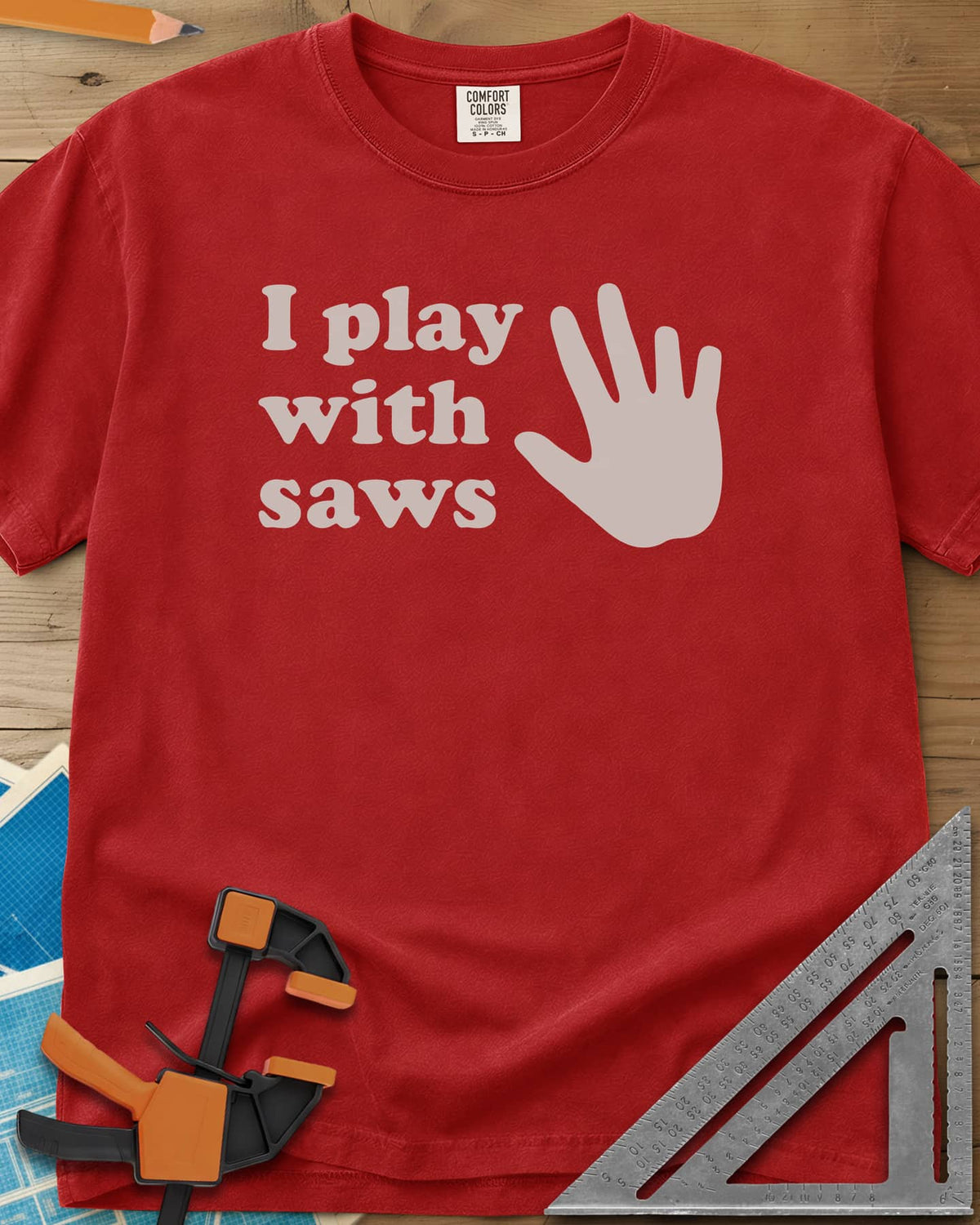 I Play With Saws heavyweight tee in Red, rounded lowercase lettering beside a big open hand, five fingers