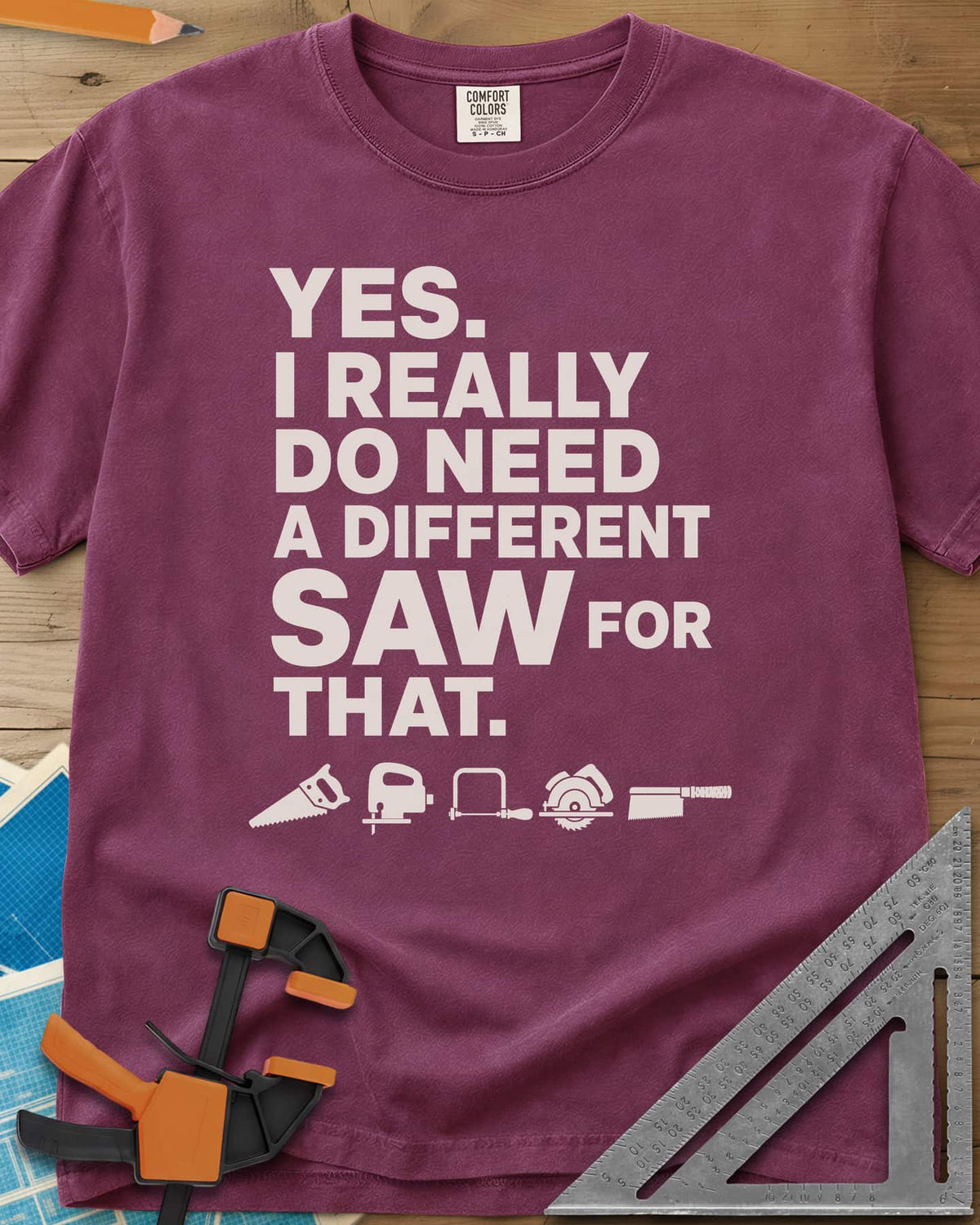 I Really Do Need A Different Saw heavyweight tee in Berry, bold stacked lettering above a row of five small saw icons