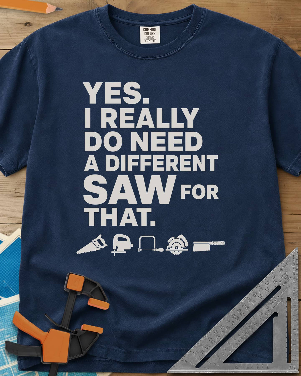 I Really Do Need A Different Saw heavyweight tee in Navy, bold stacked lettering above a row of five small saw icons