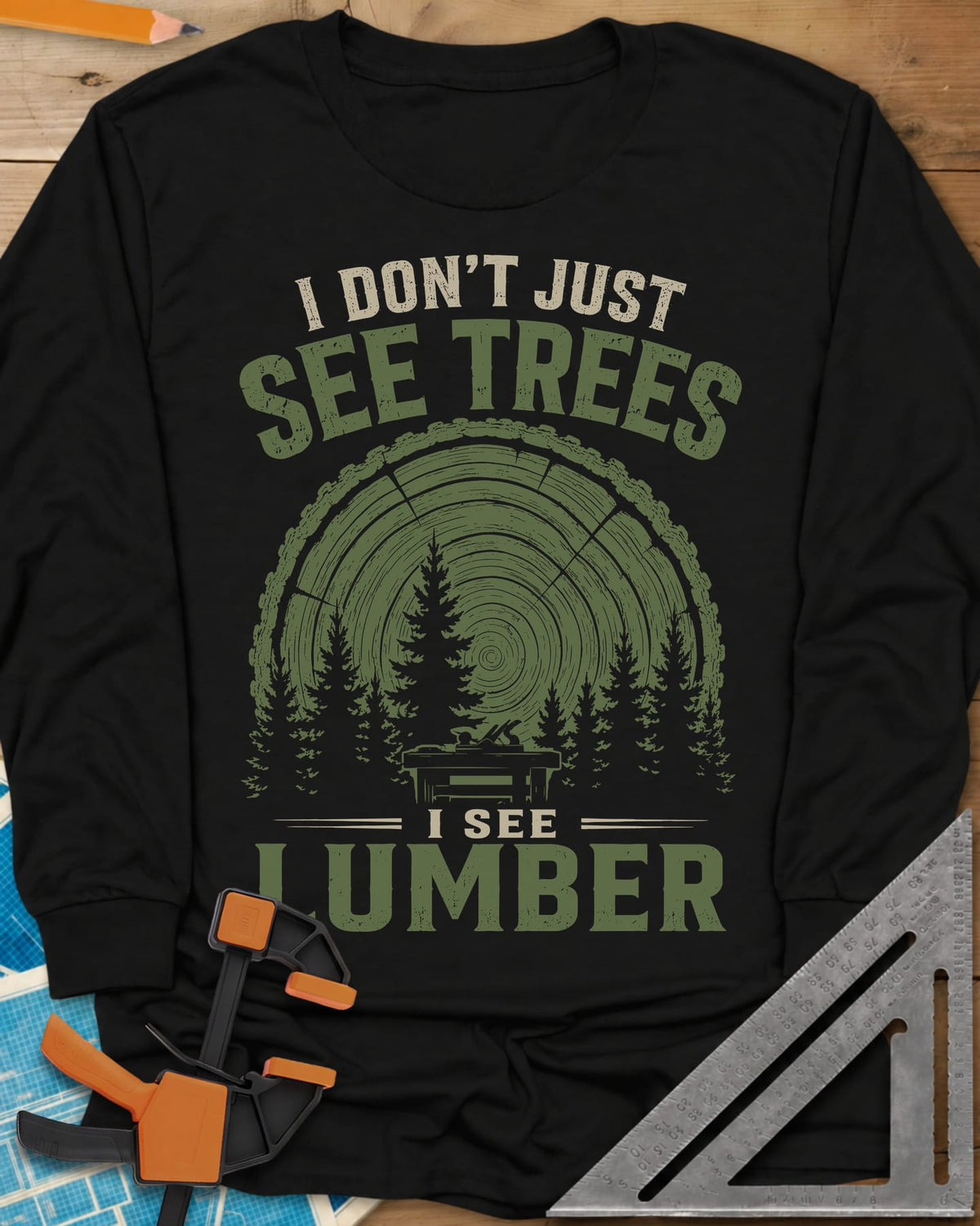 I See Lumber long sleeve shirt in Black, log growth rings, pine trees and a small workbench