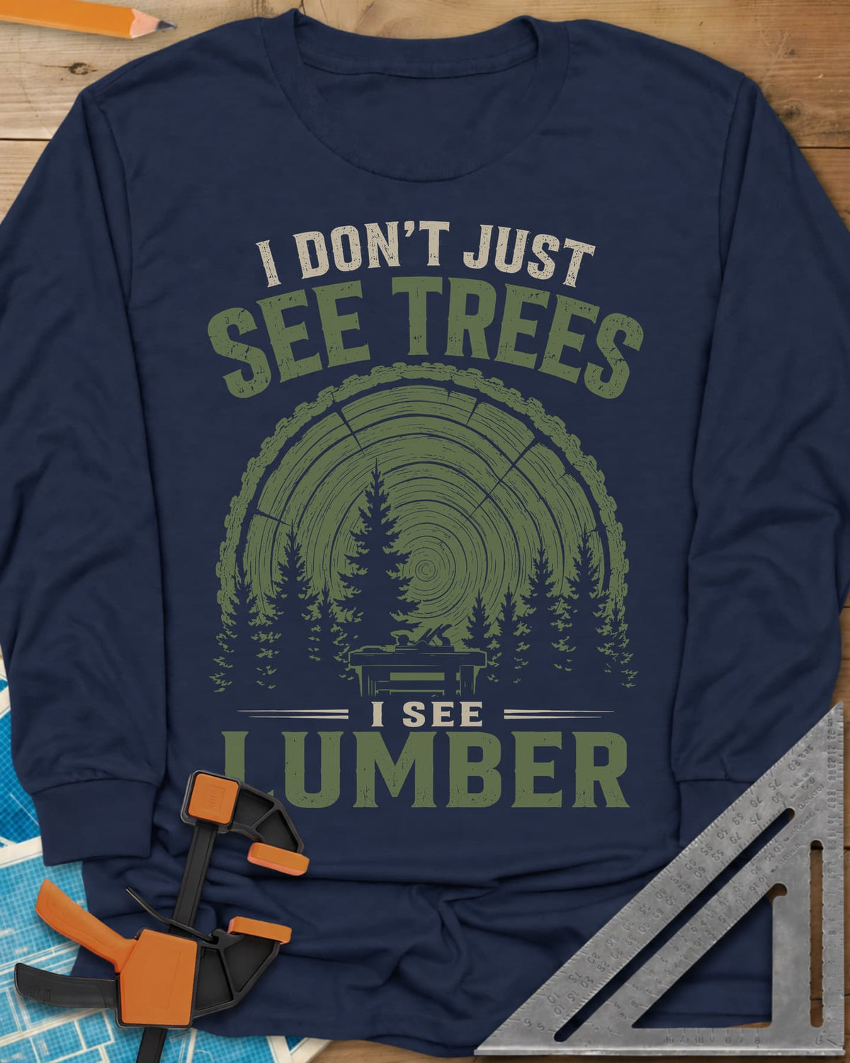 I See Lumber long sleeve shirt in Navy, log growth rings, pine trees and a small workbench