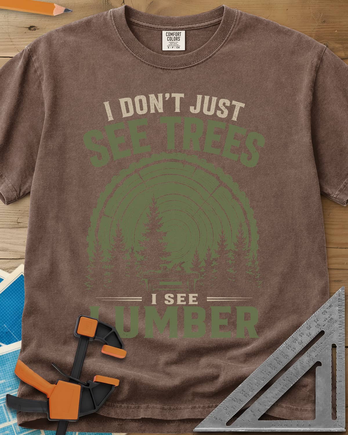 I See Lumber heavyweight tee in Espresso, log growth rings, pine trees and a small workbench
