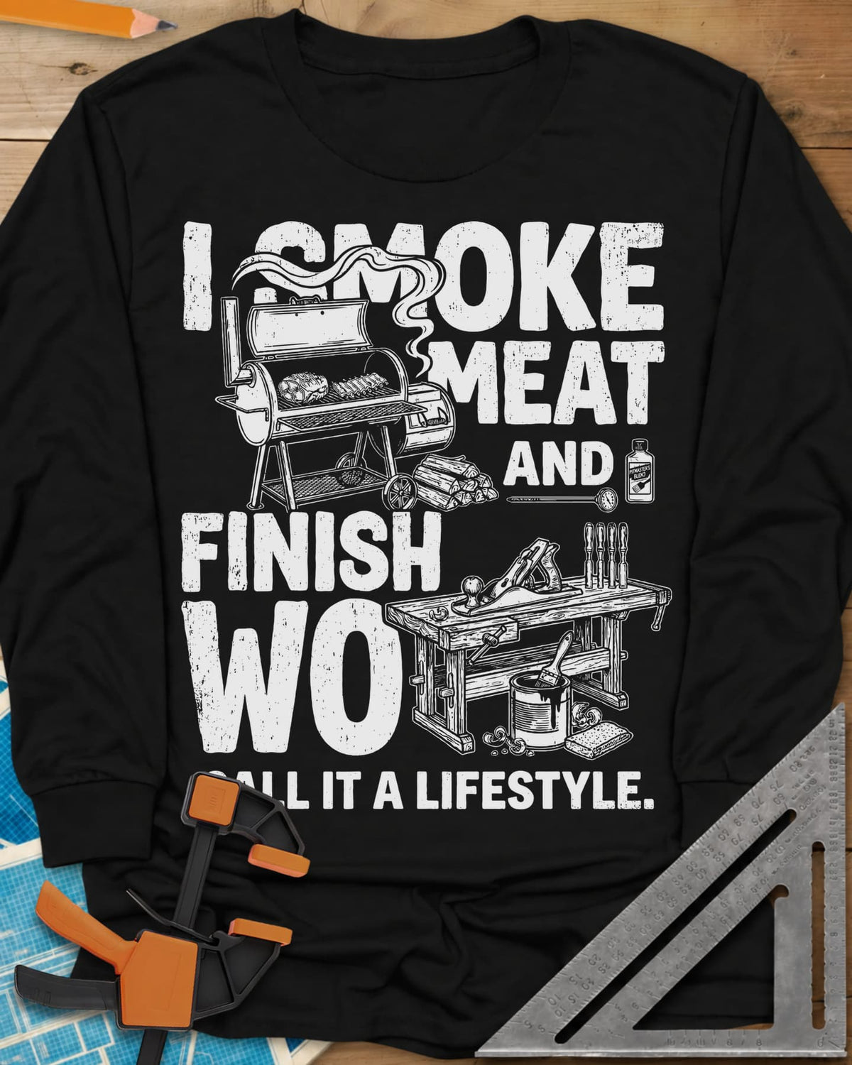 I Smoke Meat And Finish Wood long sleeve shirt in Black, an offset smoker with ribs beside a workbench with a hand plane