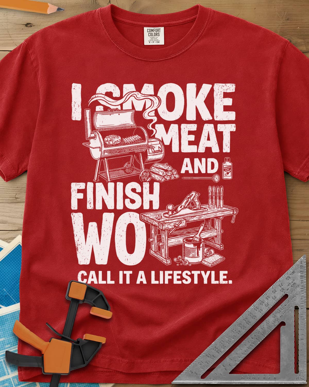 I Smoke Meat And Finish Wood heavyweight tee in Red, an offset smoker with ribs beside a workbench with a hand plane