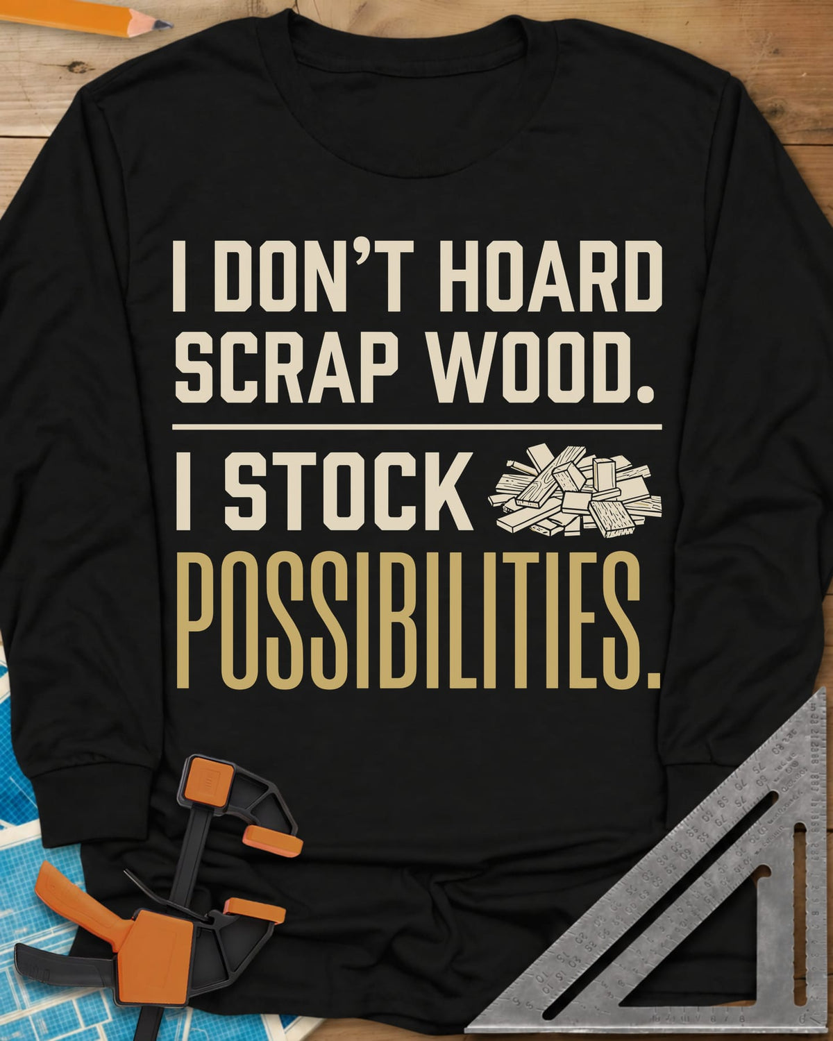 I Stock Possibilities long sleeve shirt in Black, bold lettering beside a small pile of scrap wood offcuts