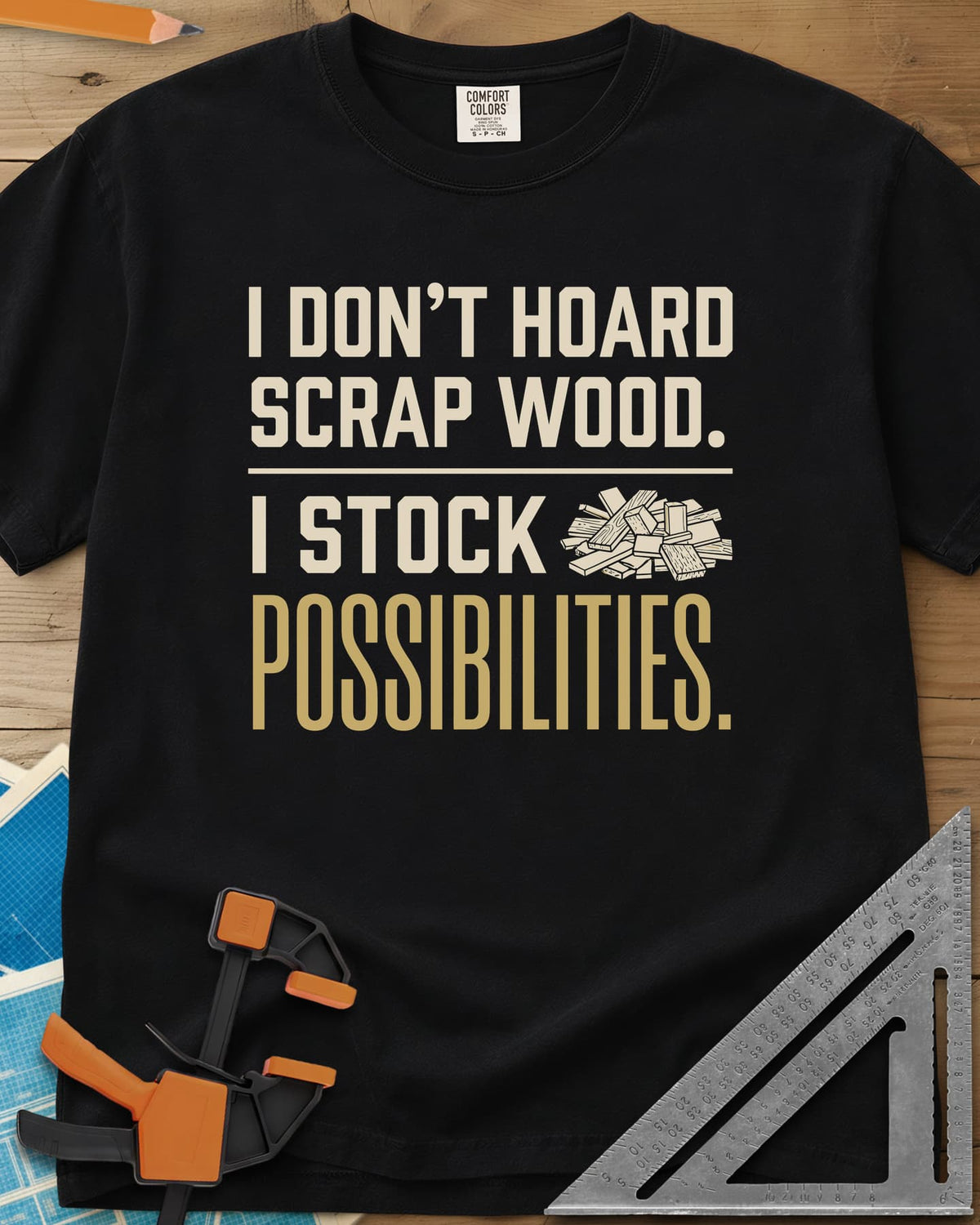 I Stock Possibilities heavyweight tee in Black, bold lettering beside a small pile of scrap wood offcuts