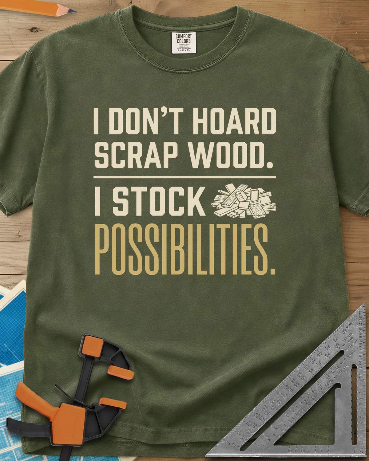 I Stock Possibilities heavyweight tee in Hemp, bold lettering beside a small pile of scrap wood offcuts