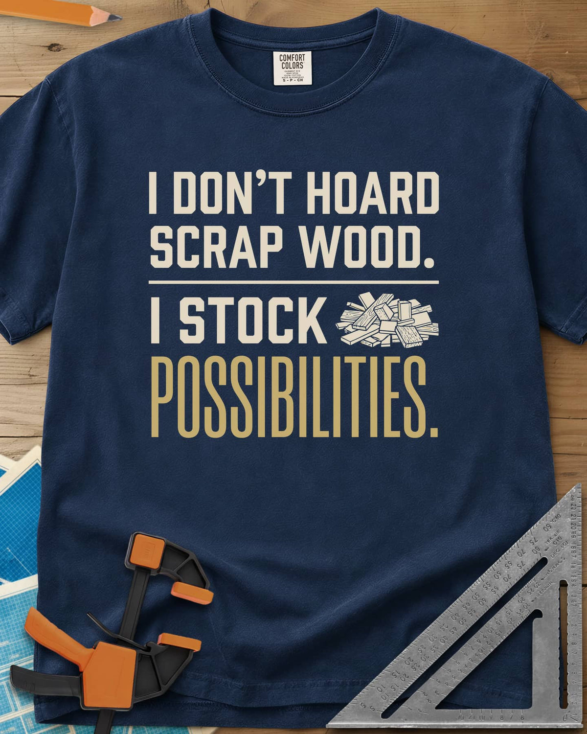 I Stock Possibilities heavyweight tee in Navy, bold lettering beside a small pile of scrap wood offcuts