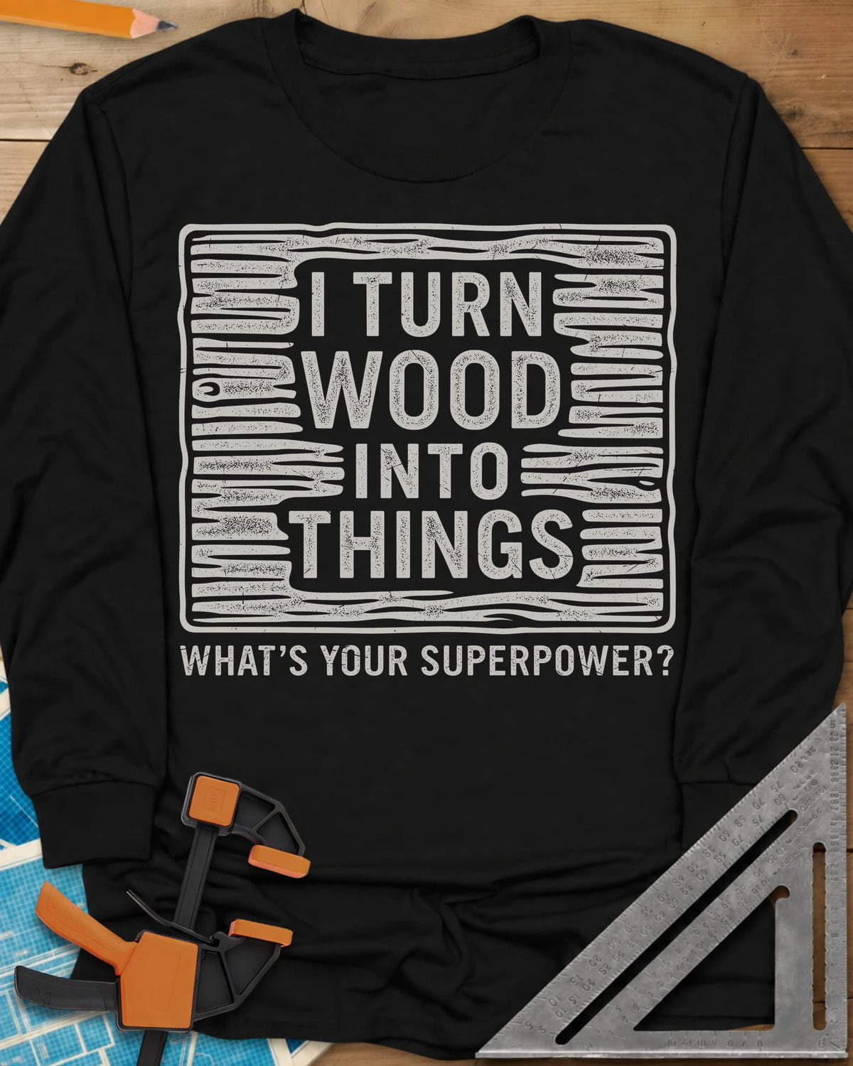 I Turn Wood Into Things long sleeve shirt in Black, stacked block lettering inside a hand-drawn wood-grain frame