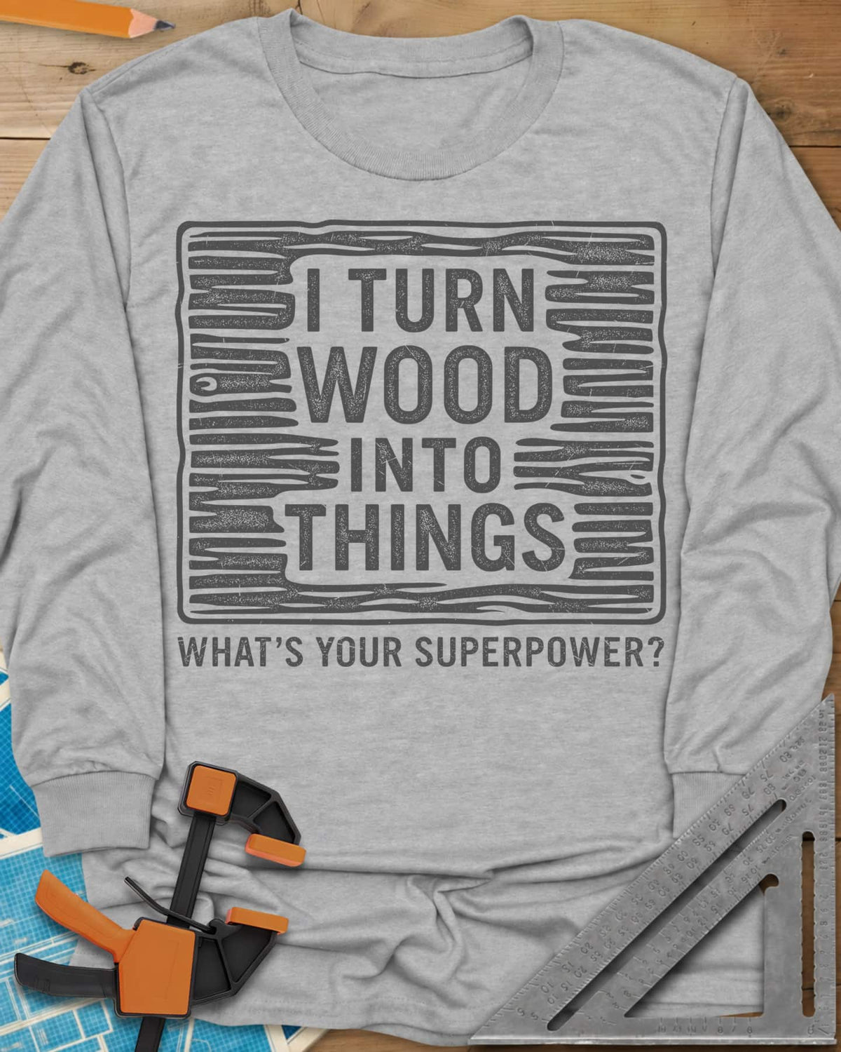 I Turn Wood Into Things long sleeve shirt in Sport Grey, stacked block lettering inside a hand-drawn wood-grain frame