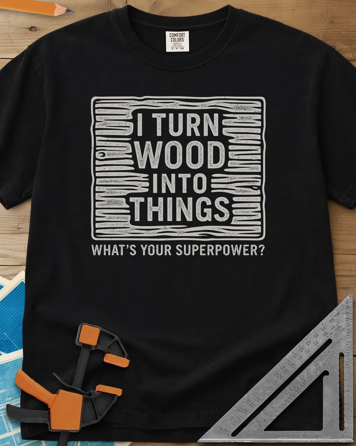 I Turn Wood Into Things heavyweight tee in Black, stacked block lettering inside a hand-drawn wood-grain frame
