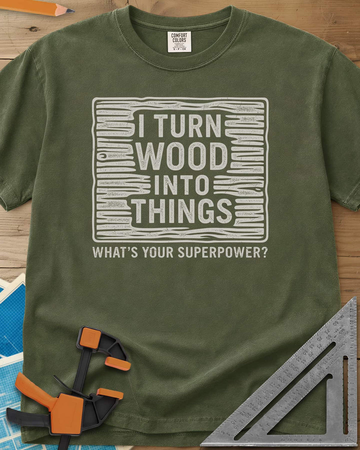 I Turn Wood Into Things heavyweight tee in Hemp, stacked block lettering inside a hand-drawn wood-grain frame