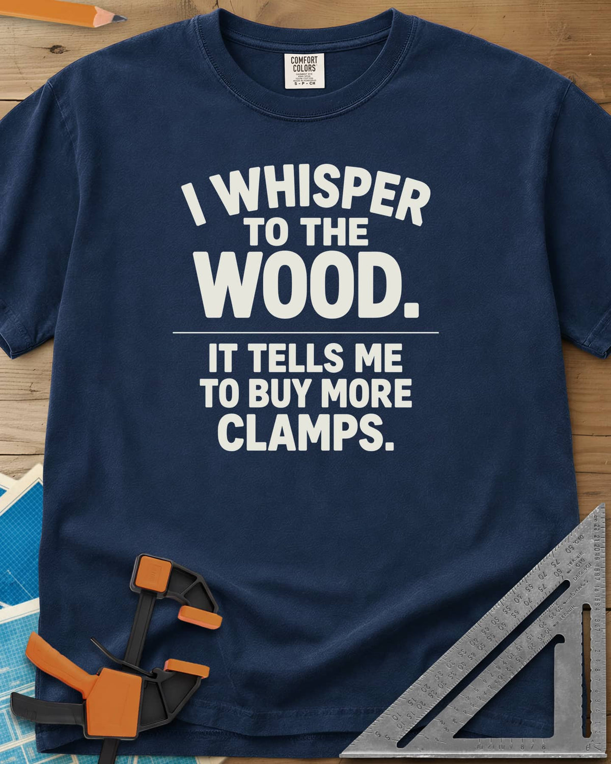 I Whisper To The Wood Clamp Humor heavyweight tee in Navy, bold stacked lettering split by a thin divider line, no graphic