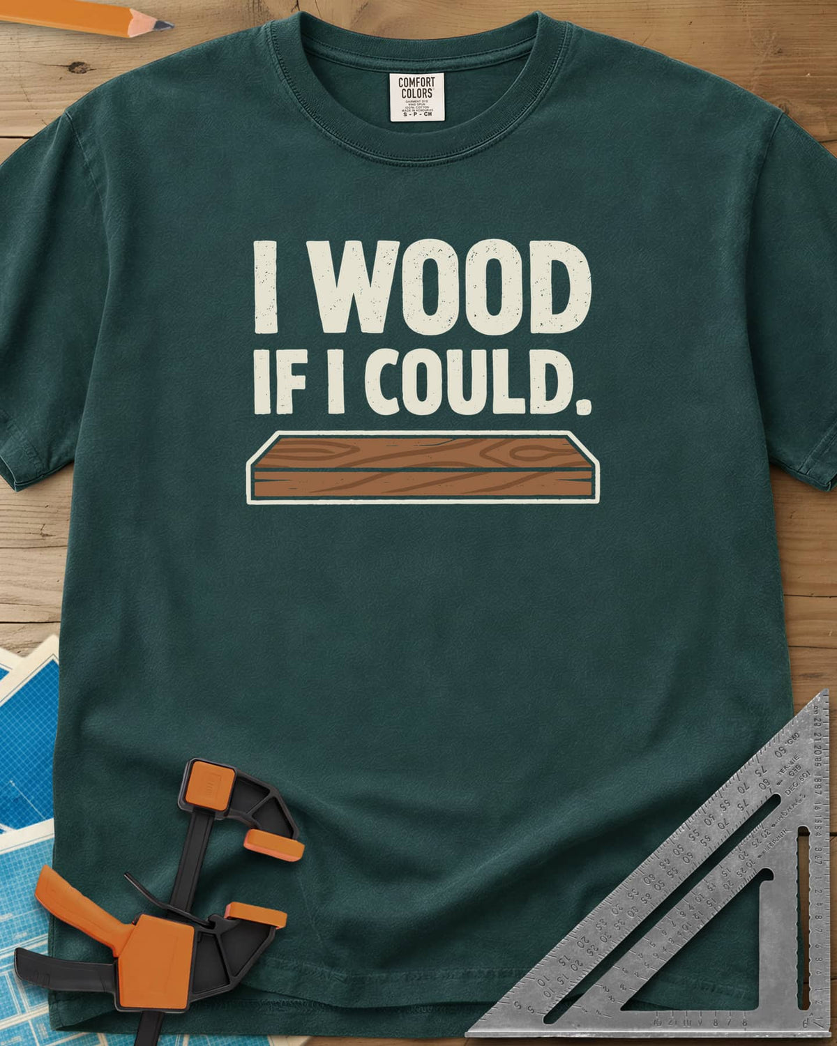 I Wood If I Could heavyweight tee in Blue Spruce, distressed lettering above a drawn wood plank with grain