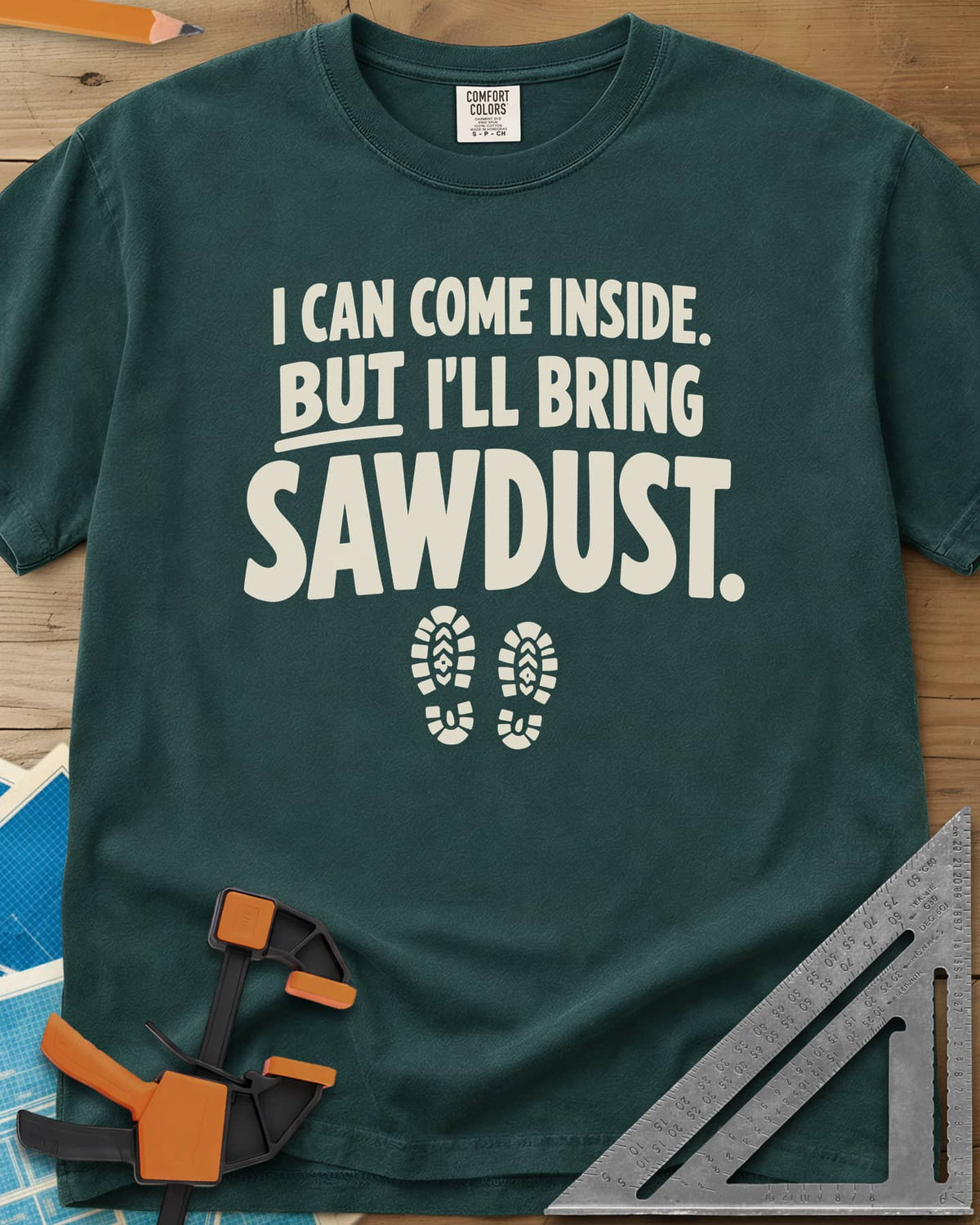 I'll Bring Sawdust heavyweight tee in Blue Spruce, bold lettering above a pair of boot prints