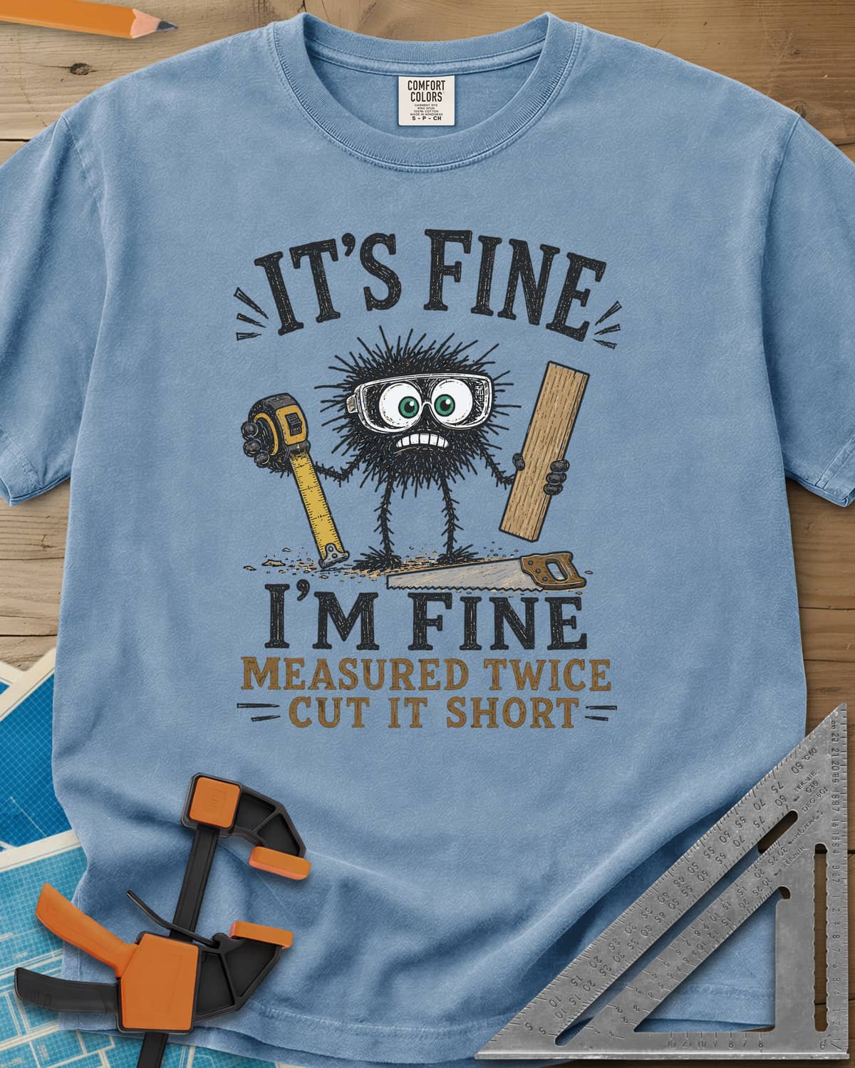 I’m Fine heavyweight tee in Washed Denim, a fuzzy goggled creature holding a tape measure and a board