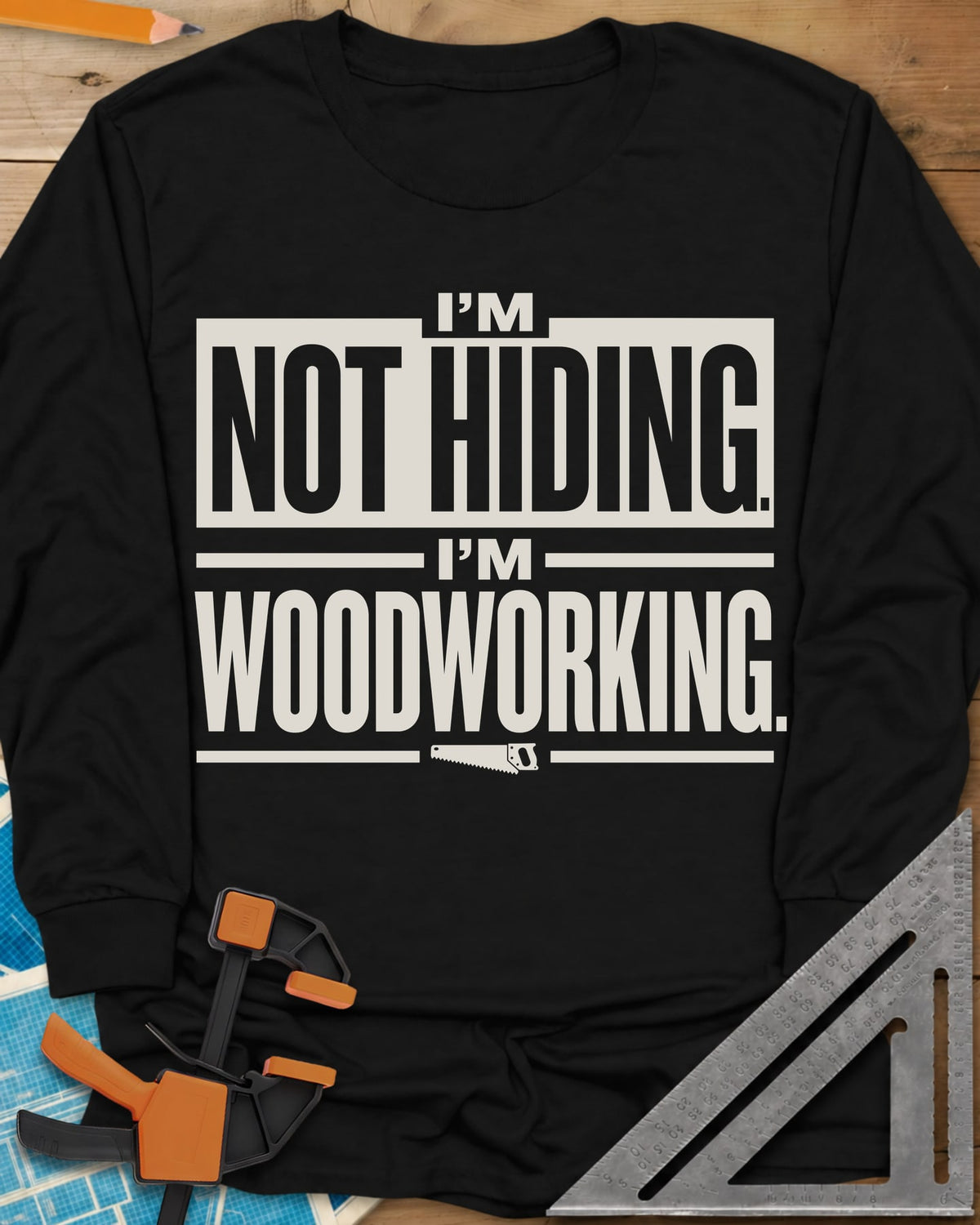 I'm Not Hiding I'm Woodworking long sleeve shirt in Black, block lettering with a knocked-out box and a small handsaw