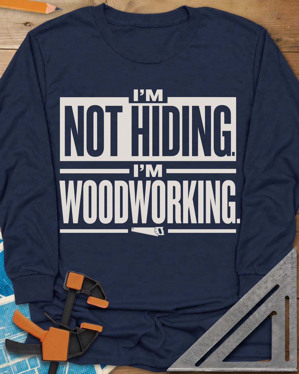 I'm Not Hiding I'm Woodworking long sleeve shirt in Navy, block lettering with a knocked-out box and a small handsaw