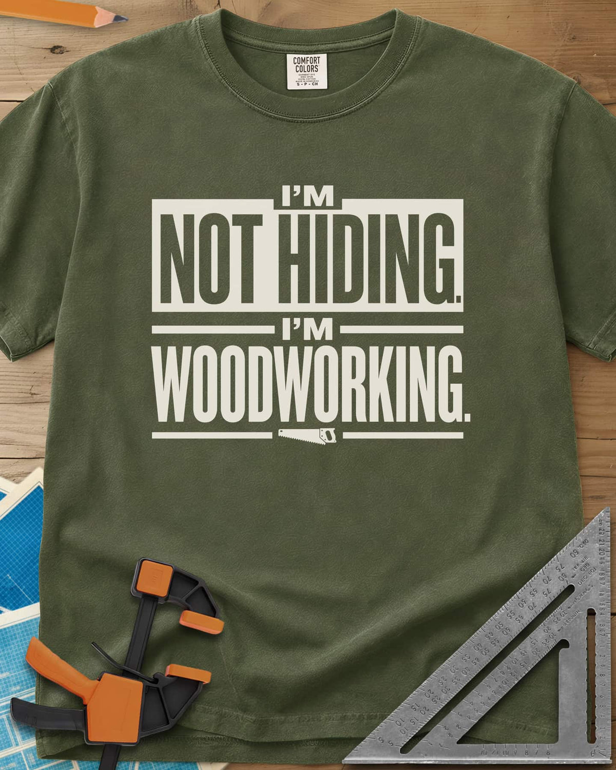 I'm Not Hiding I'm Woodworking heavyweight tee in Hemp, block lettering with a knocked-out box and a small handsaw
